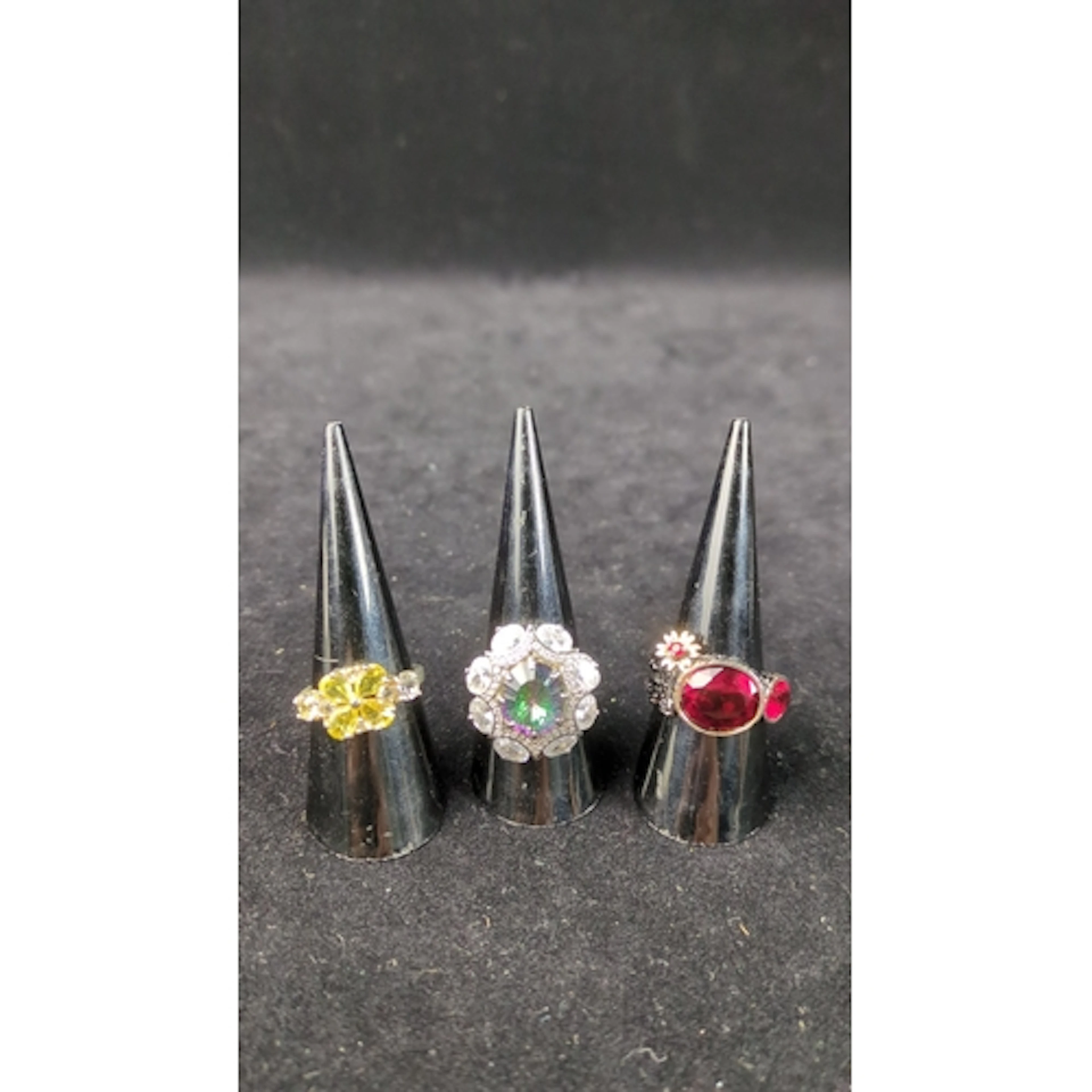 Three rings, one stamped 925 siver: one with a yellow floral...