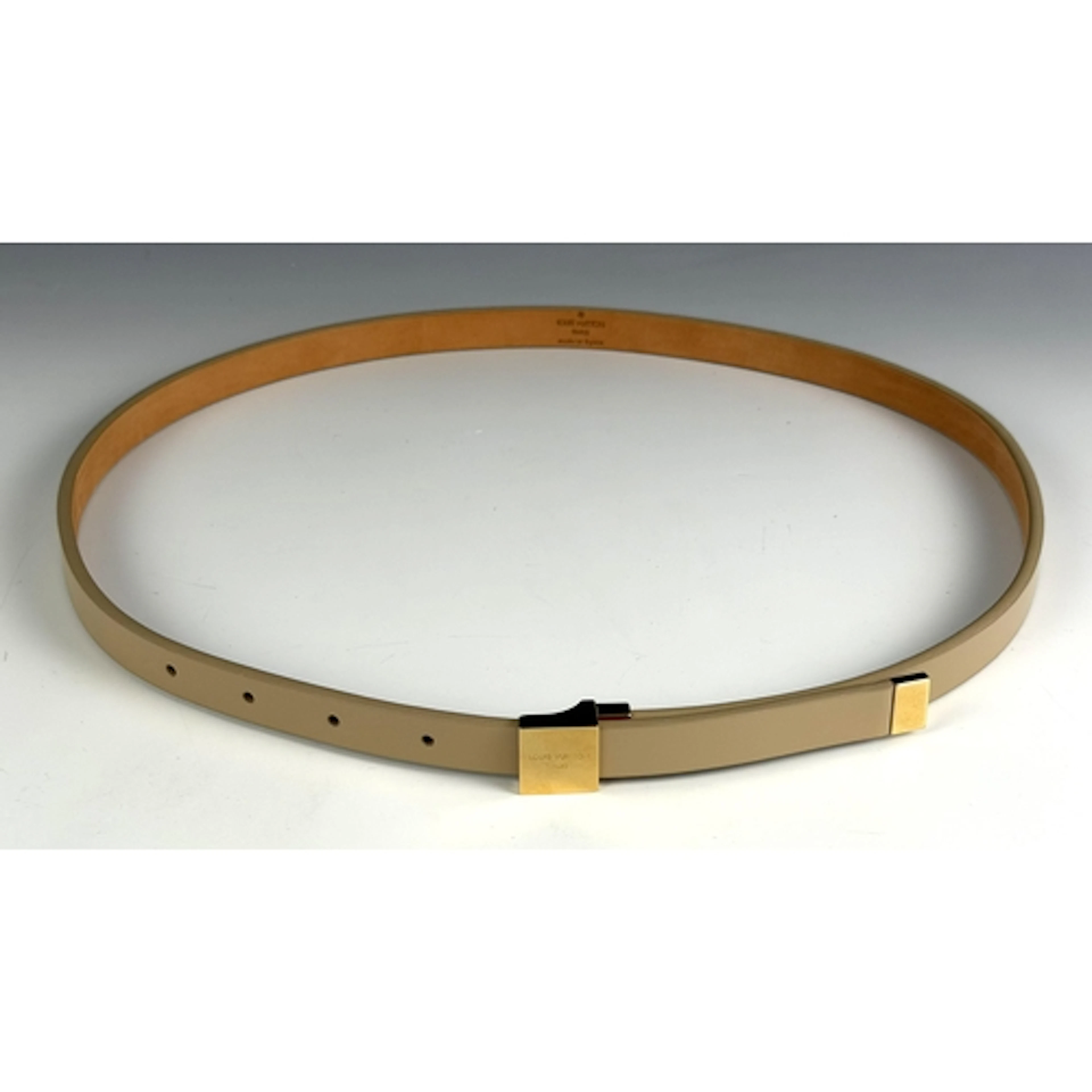 A Louis Vuitton cream coloured belt, with gold coloured squa...