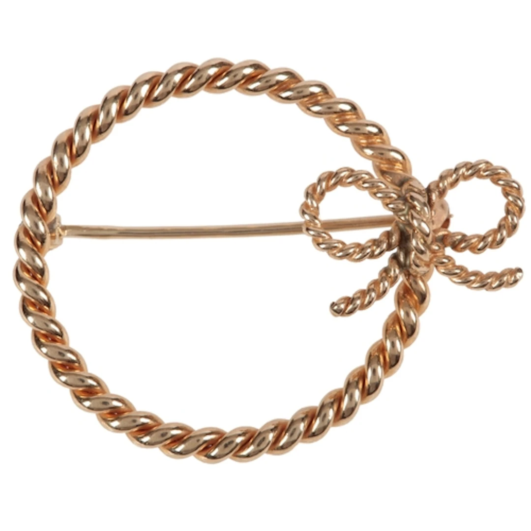A gold brooch, of circular outline with a bow motif, in rope...