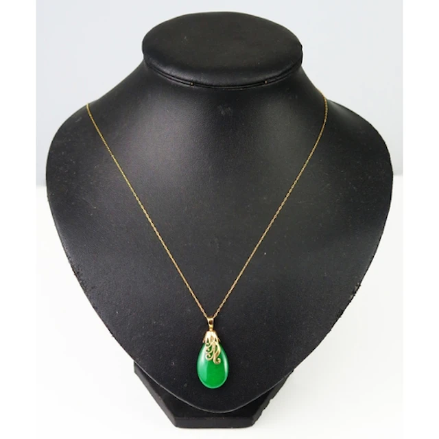 A jade pendant in a yellow ,metal mount and on a 14K gold ch...