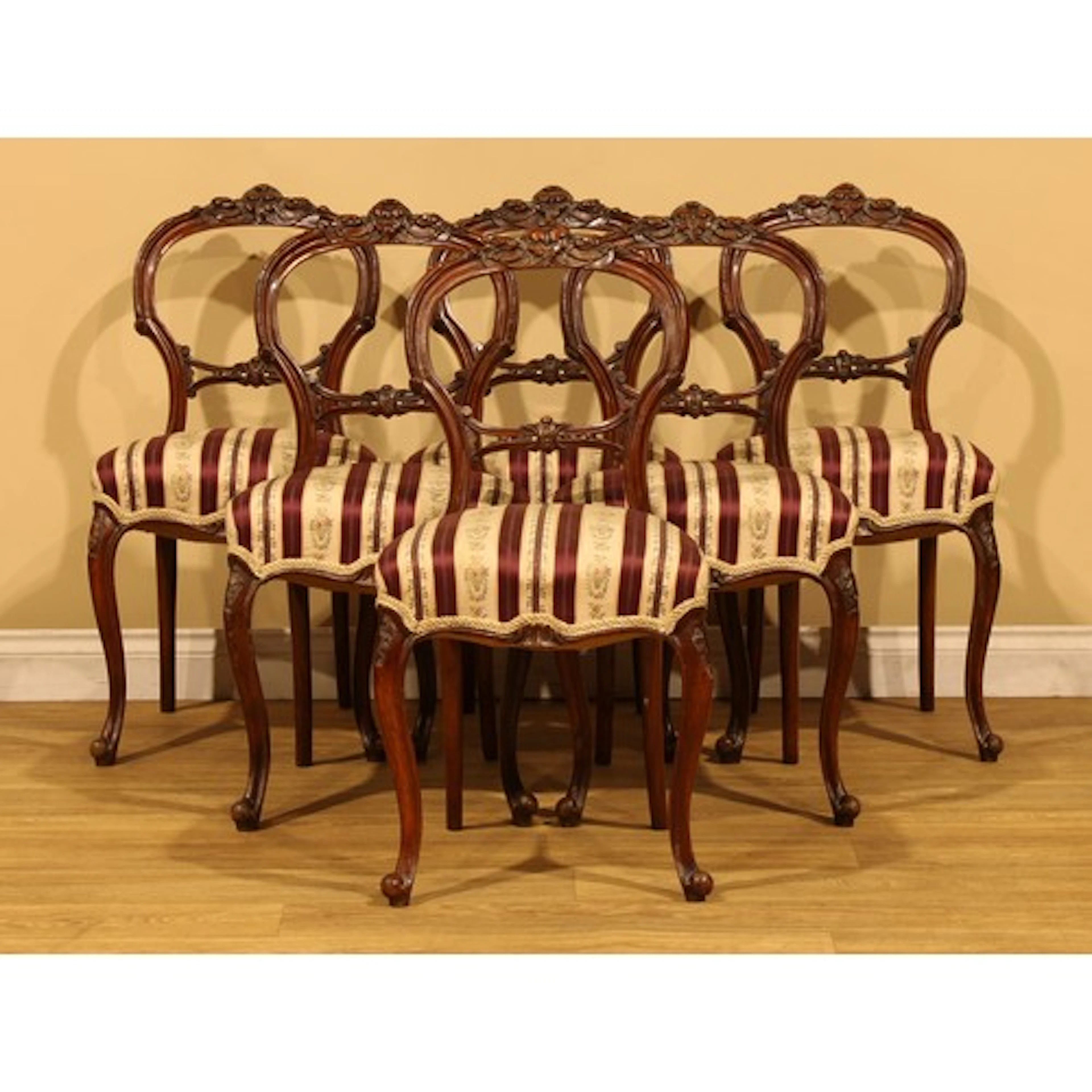 A set of six Victorian walnut dining chairs, each back carve...