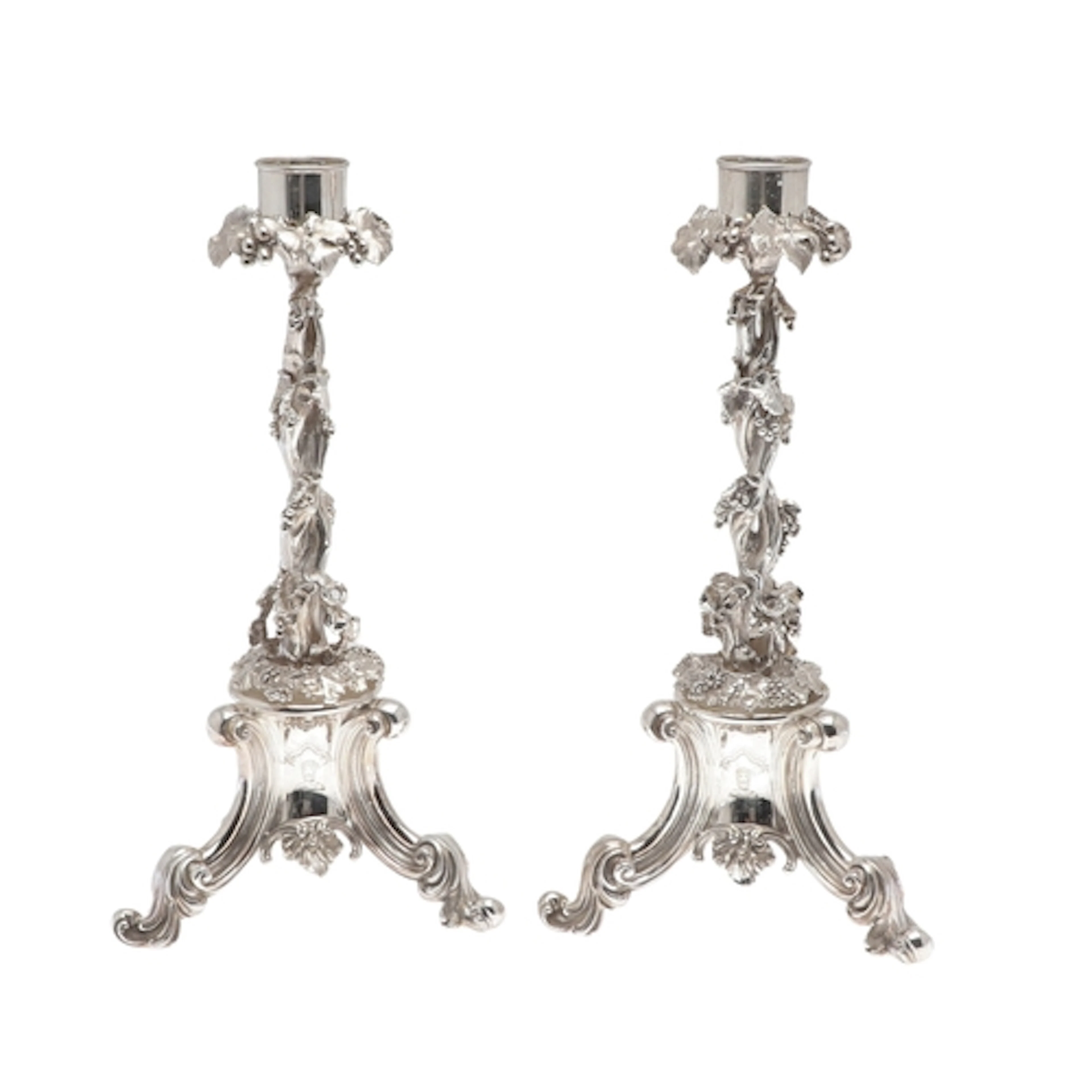 A PAIR OF ORNATE SILVER PLATED CAST CANDLESTICKS. The capita...