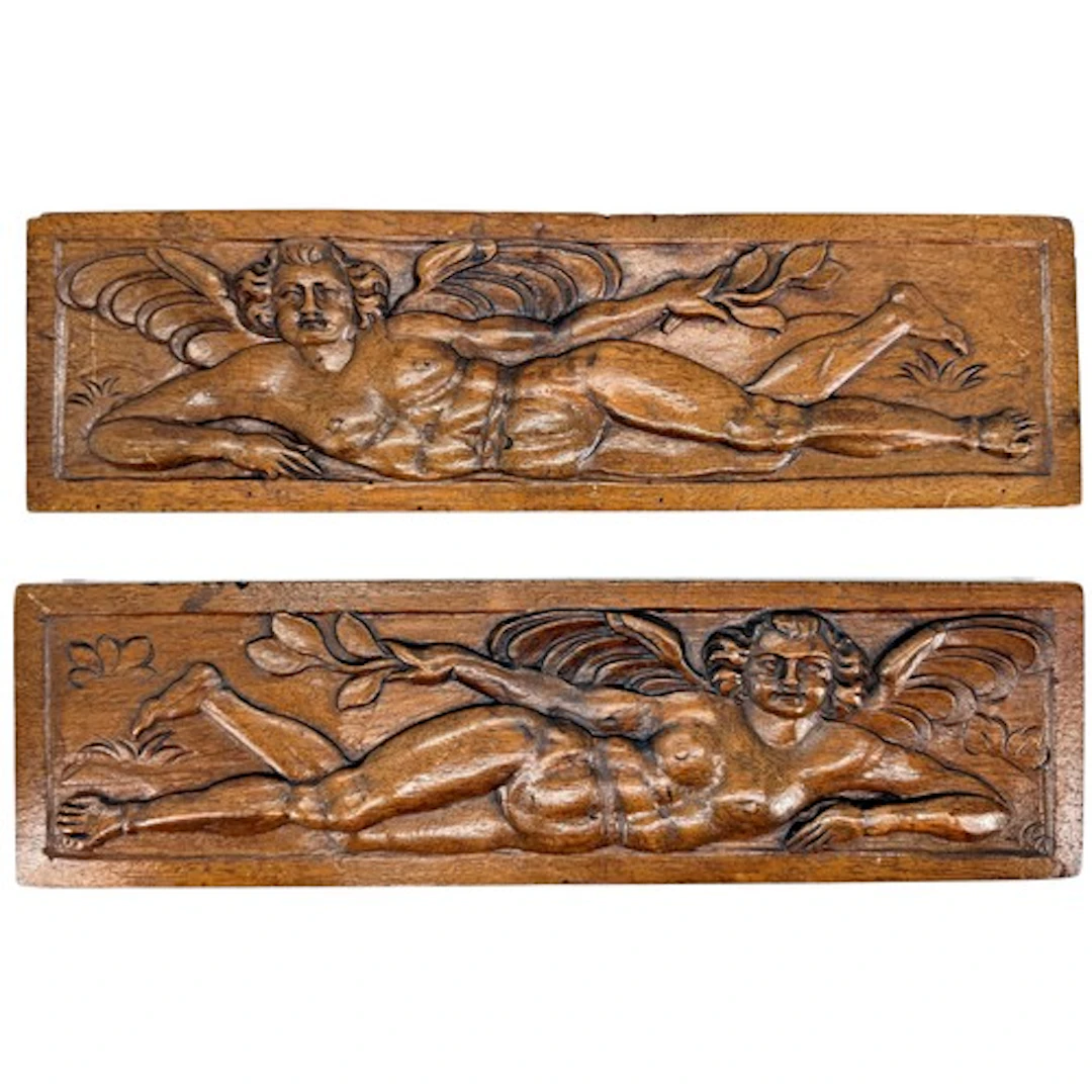 A pair of Renaissance carved walnut drawer fronts with winge...
