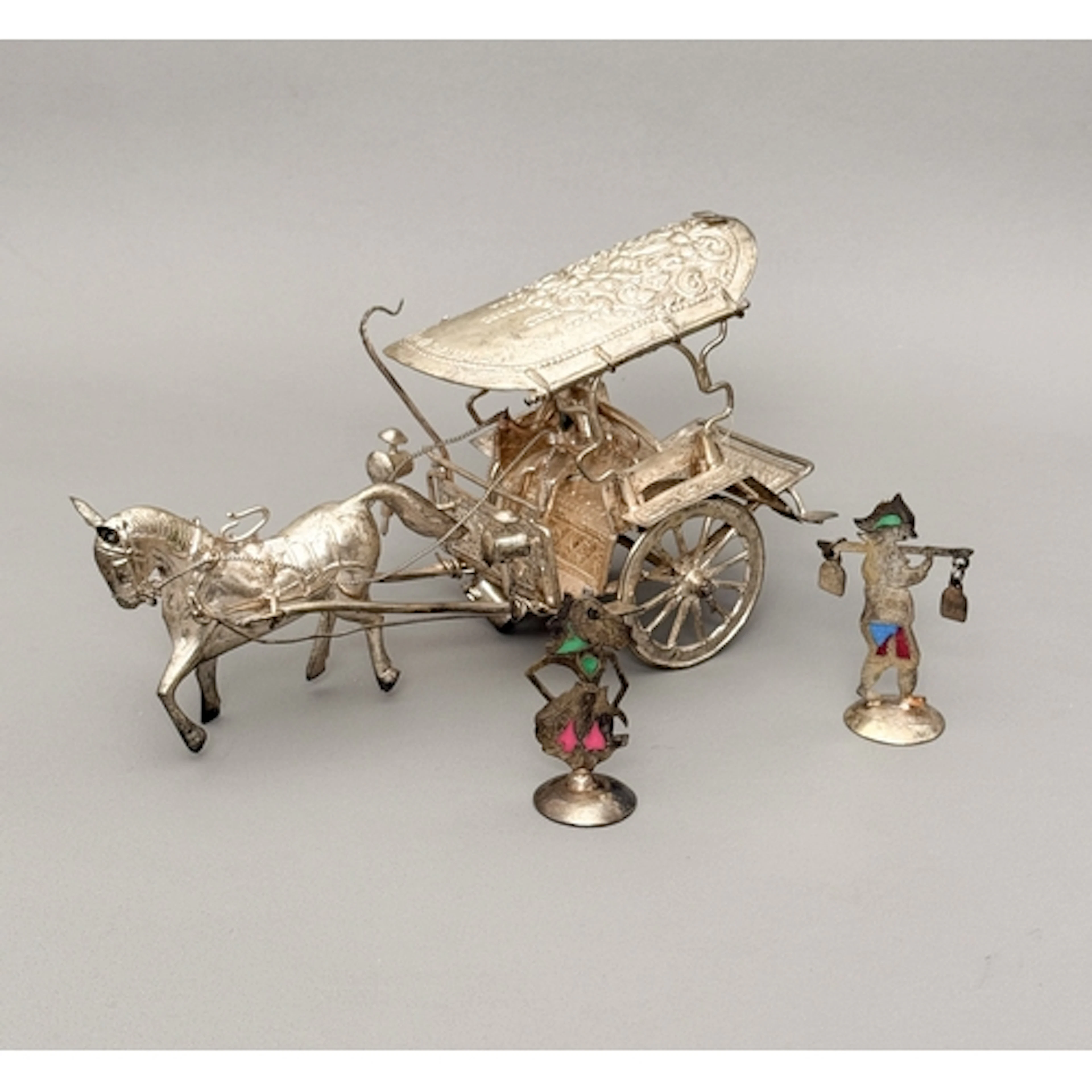 A white metal ornamental figurine of a horse drawn carriage ...