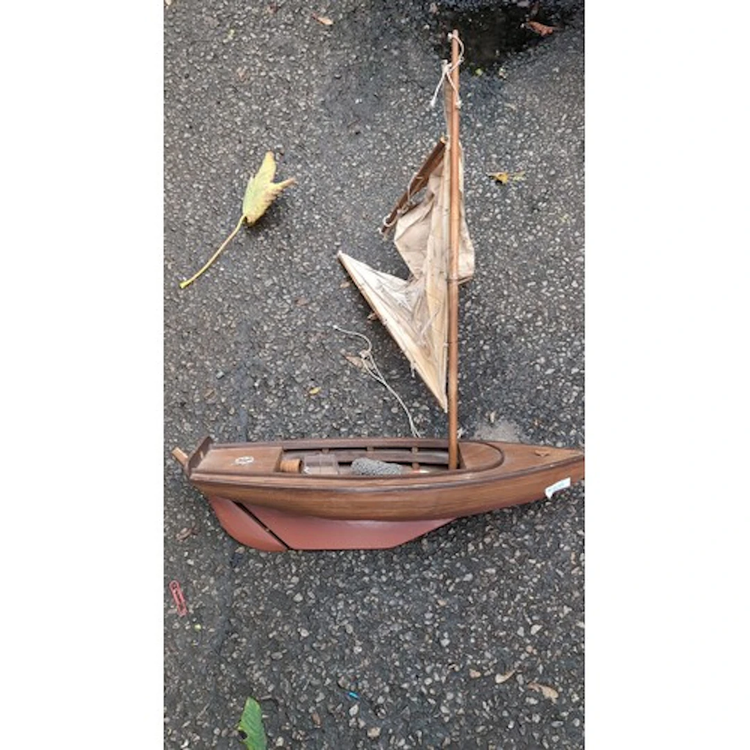 Wooden model fishing boat with a single mast, canvas sails a...
