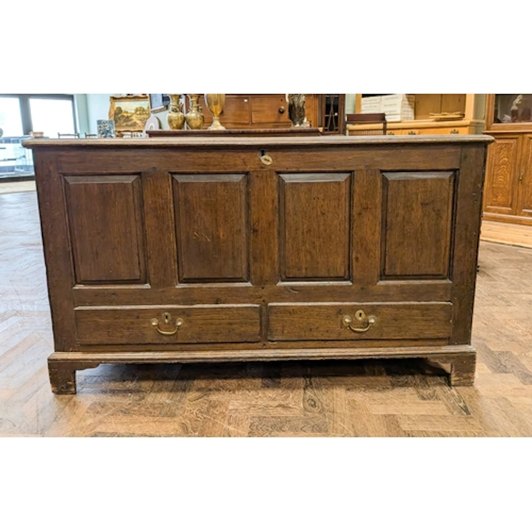 An antique oak mule chest of four fielded panels with two dr...