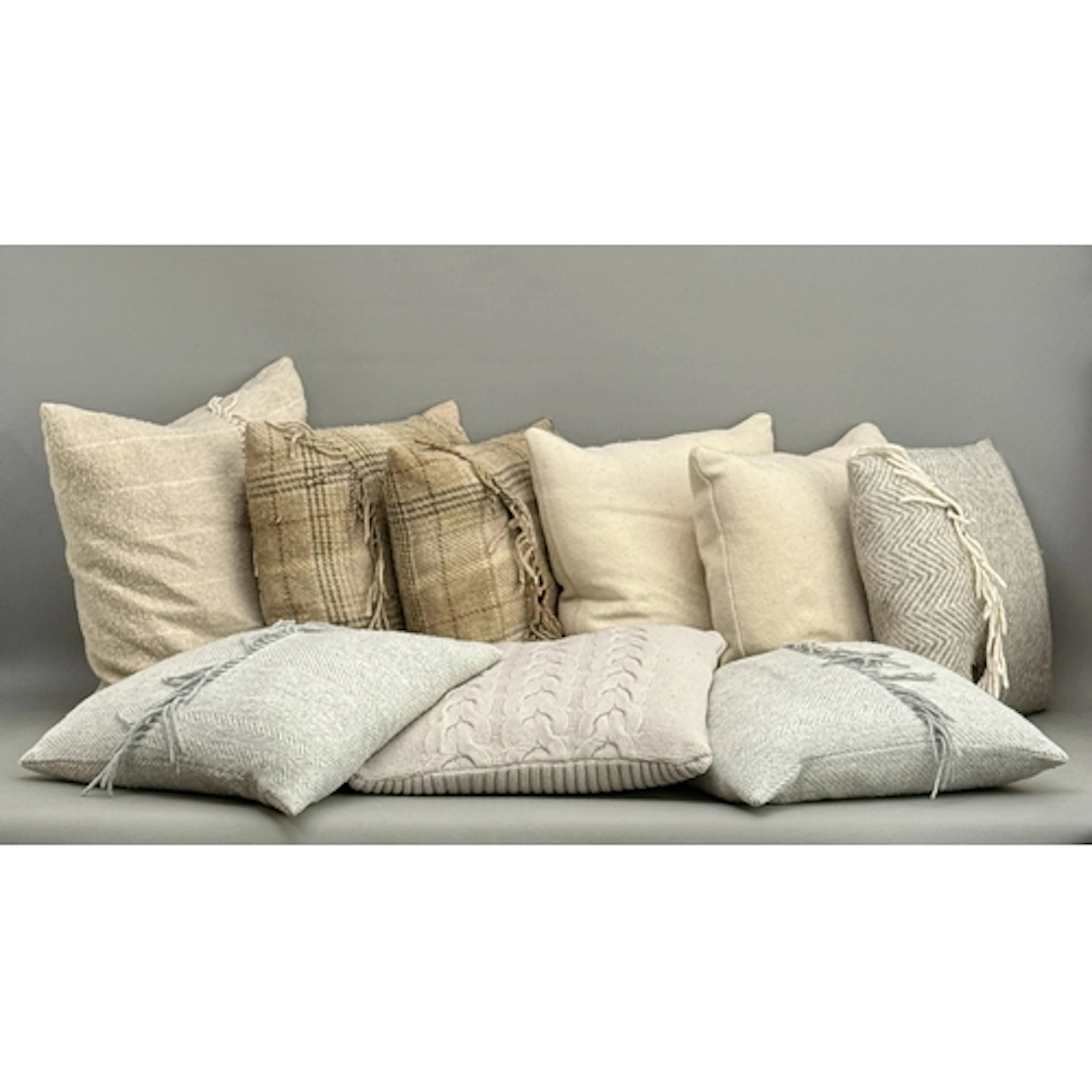 Nine cushions in a neutral palette including one cream wool ...