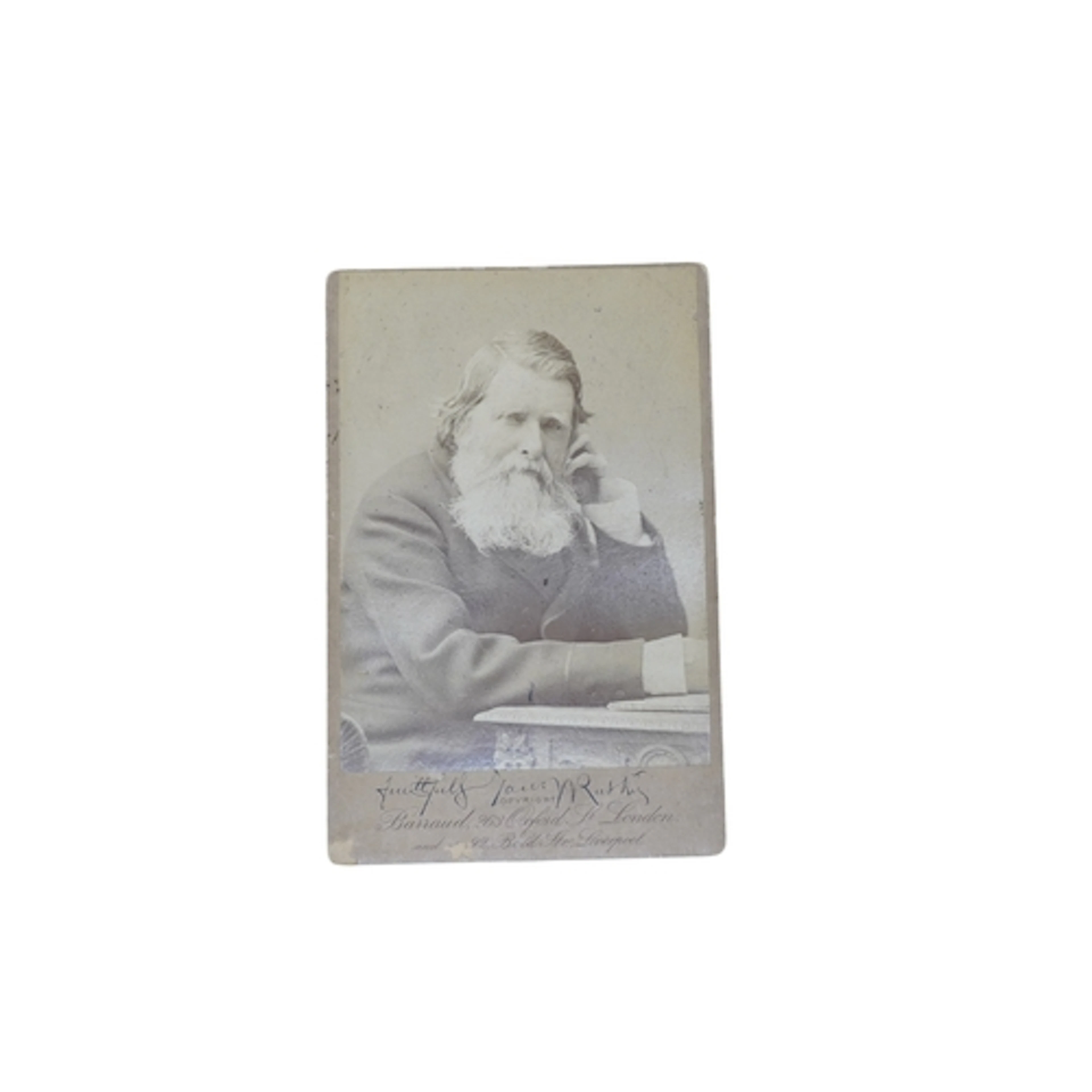 Ruskin, John. cabinet photo. seated at a table and signed be...