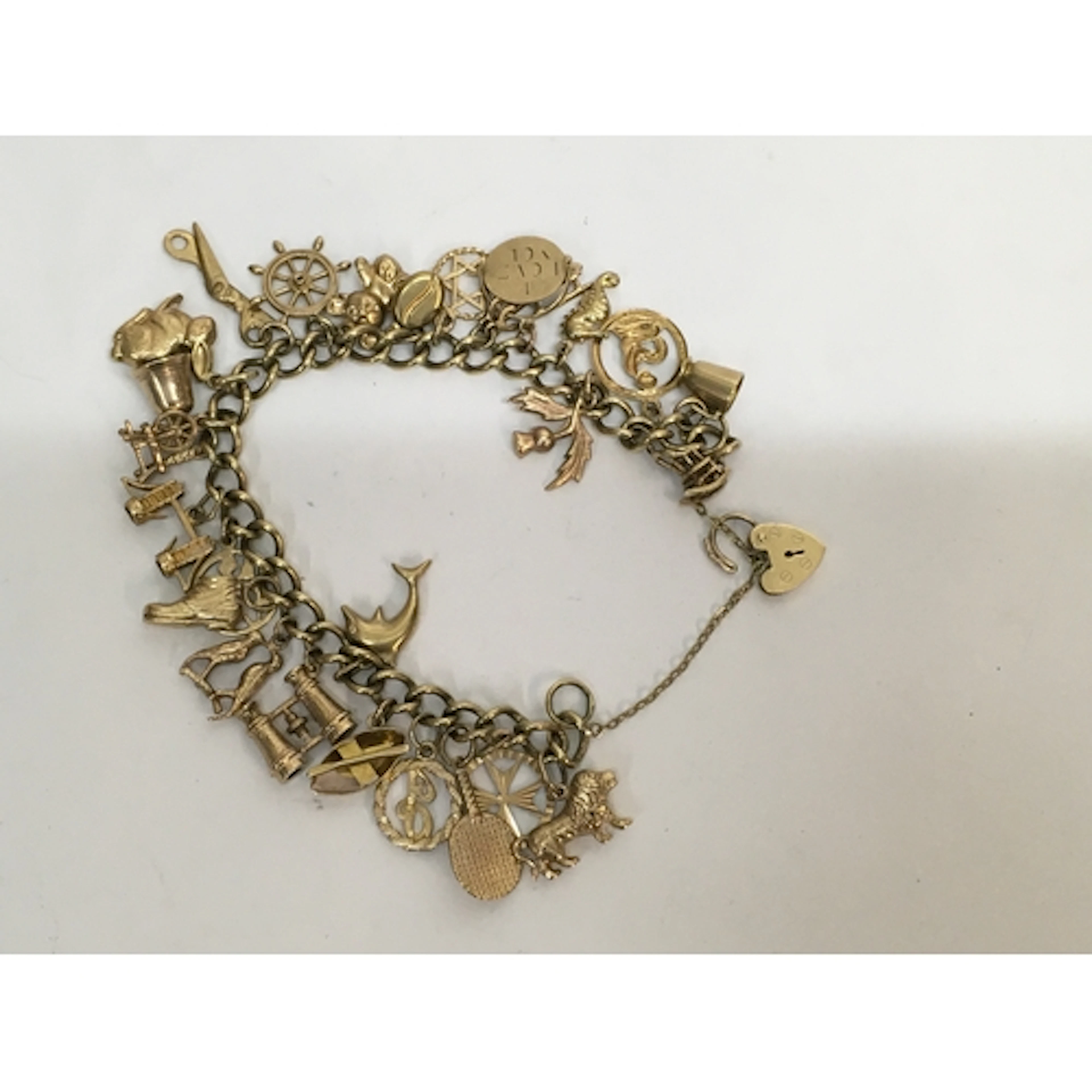 A 9ct gold charm bracelet set with various charms, many stam...