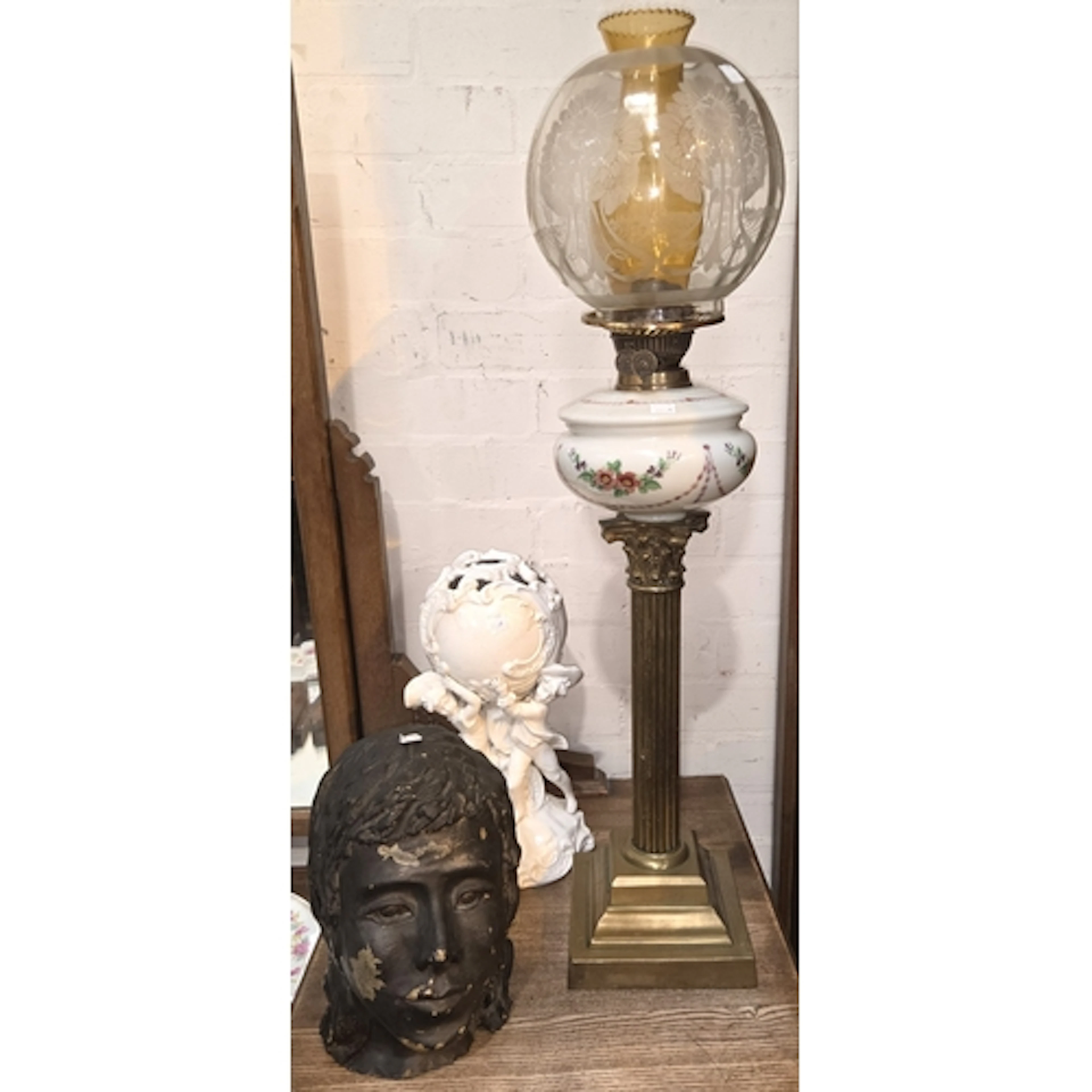 A brass Corinthian column oil lamp duplex with painted reser...