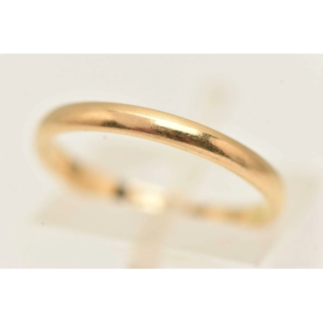 A YELLOW METAL BAND RING, of plain polished design, stamped ...