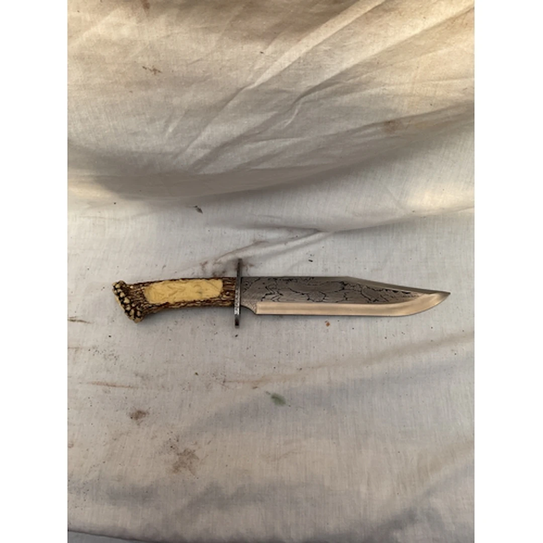 Ornate modern Bowie knife with faux stag grip.