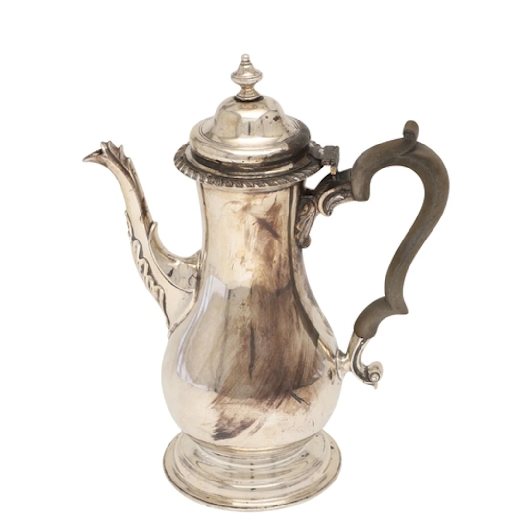 AN EDWARDIAN SILVER COFFEE POT. Of baluster form, with scrol...