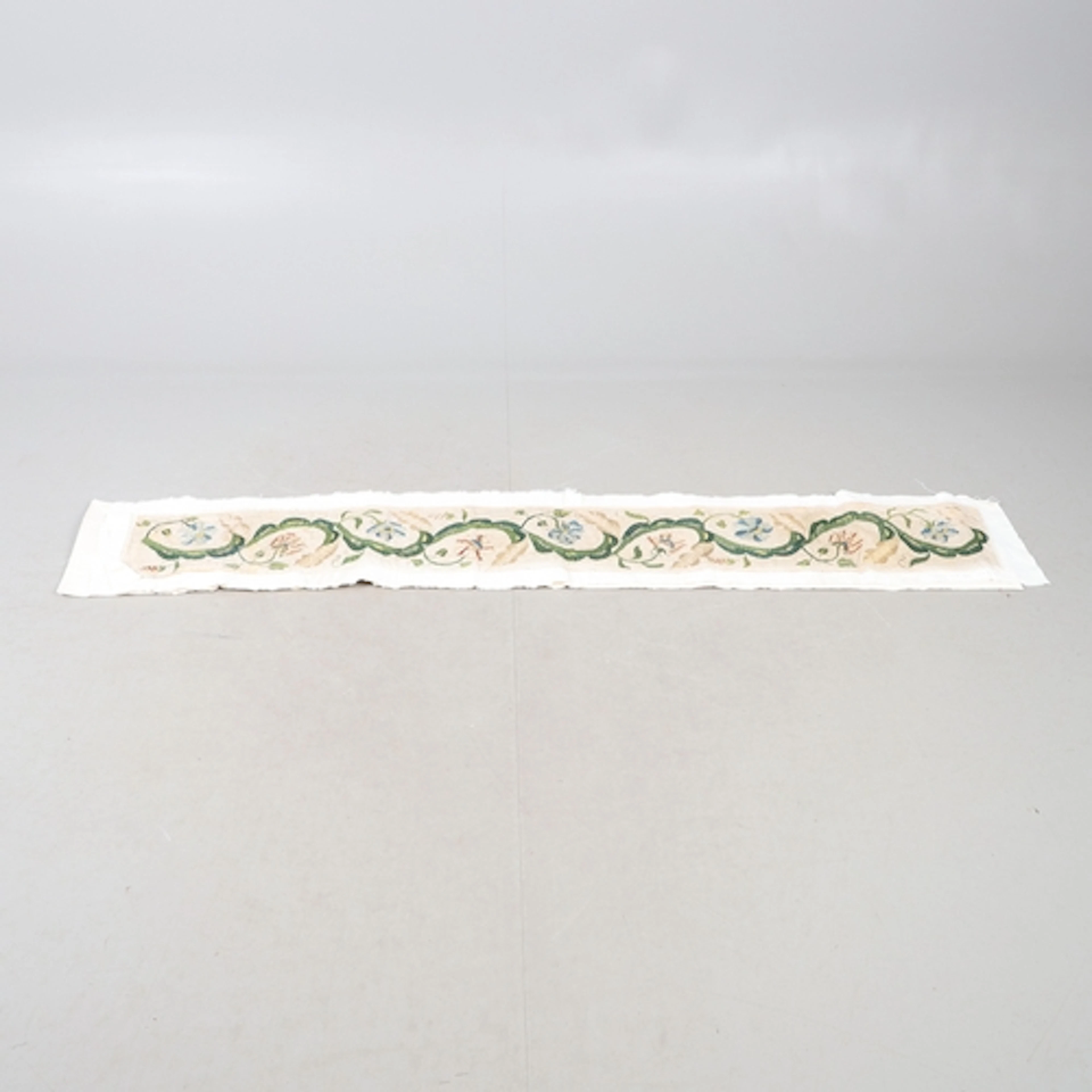 A LENGTH OF 18TH CENTURY EMBROIDERY. the design of flowers a...