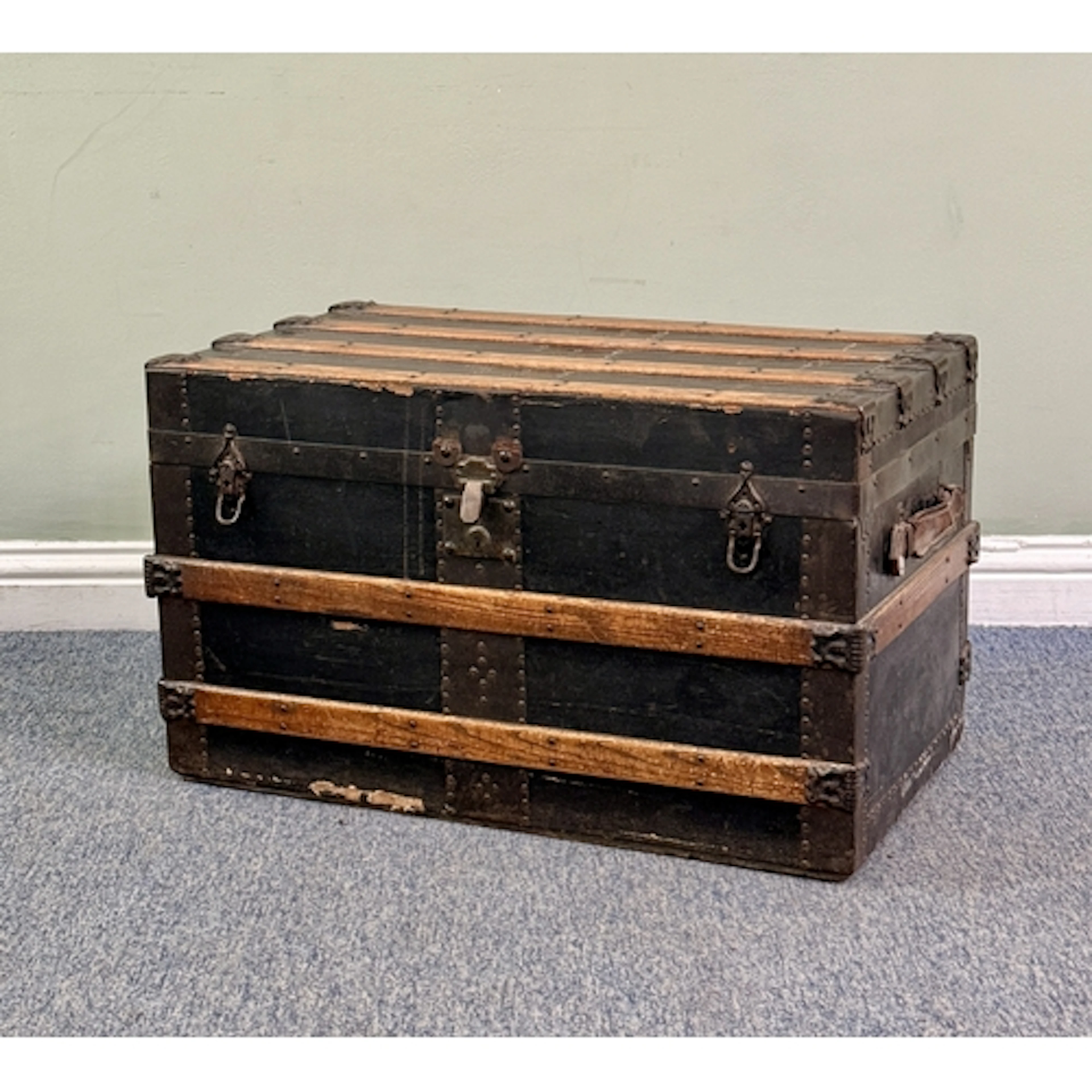 An early 20th century steamer trunk - the black rexine-cover...