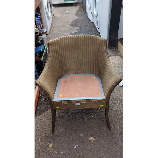 Woven rattan-effect tub armchair with a curved back and inte...
