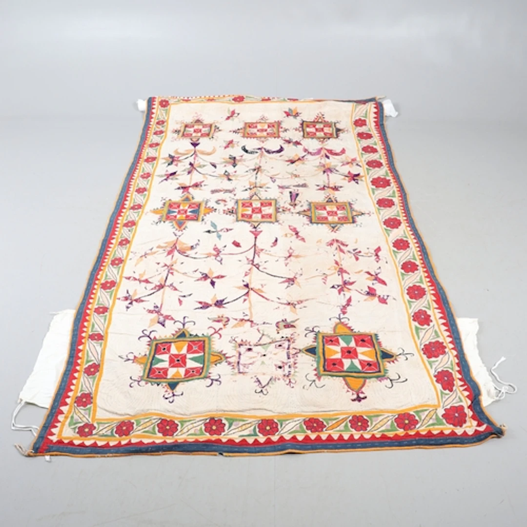 A SUZANI EMBROIDERED PANEL. A 19th century embroidered linen...