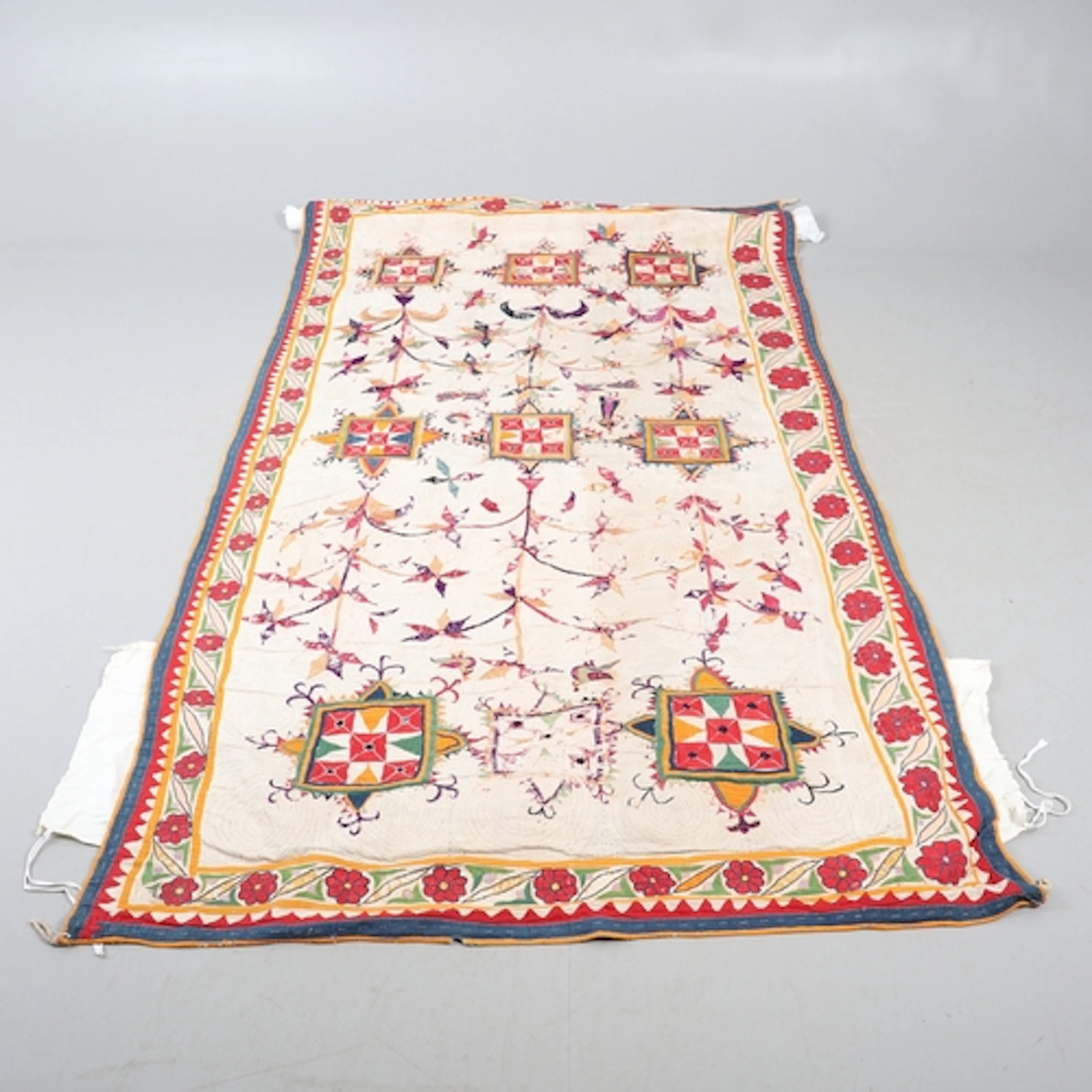A SUZANI EMBROIDERED PANEL. A 19th century embroidered linen...