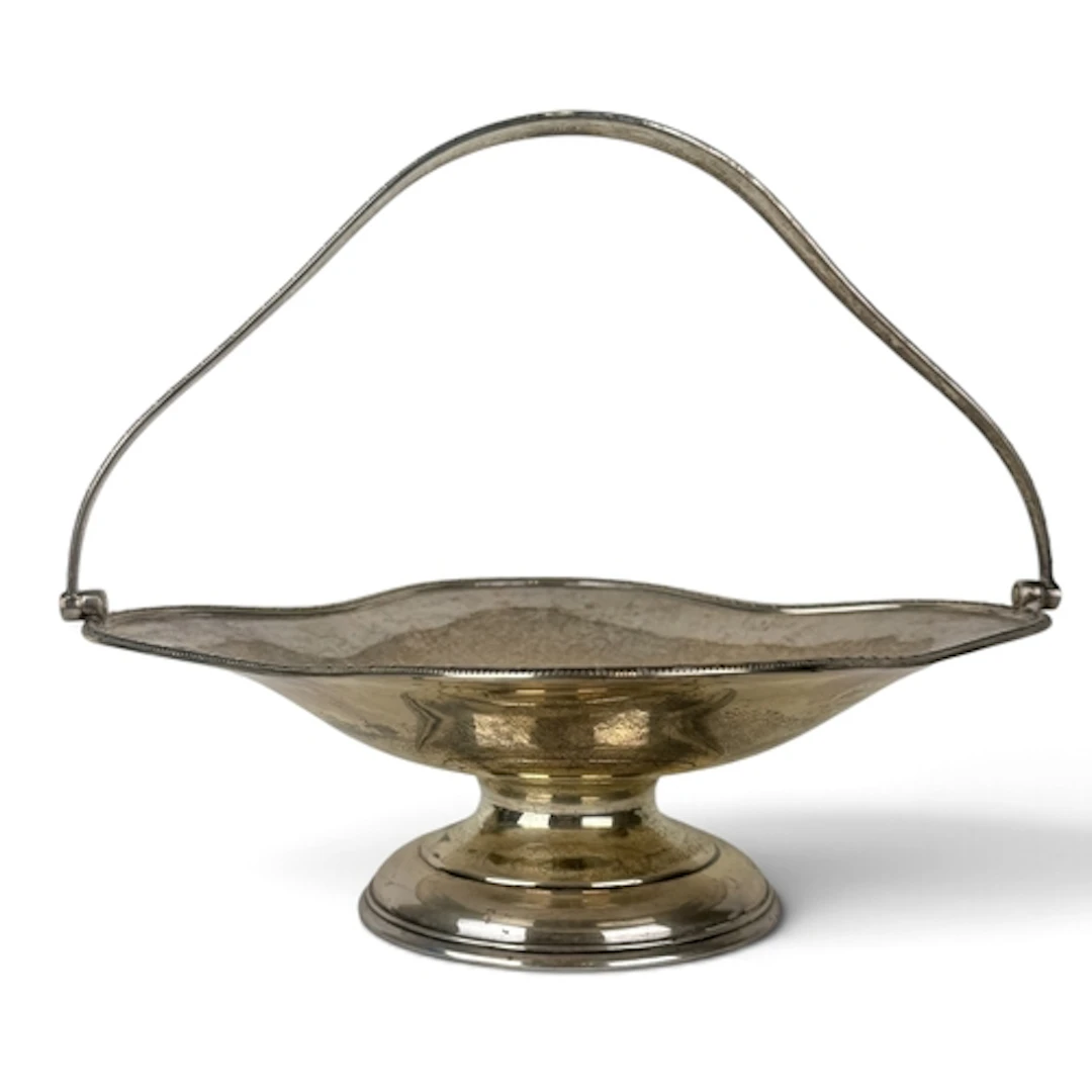 A GEORGE V SILVER PEDESTAL FRUIT BASKET WITH SWING HANDLE, L...