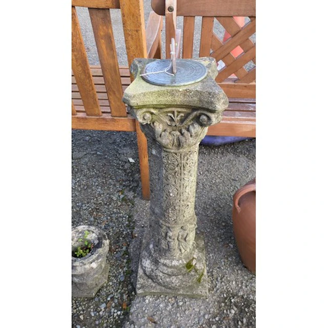 Cast-stone garden sundial with a circular metal dial inscrib...