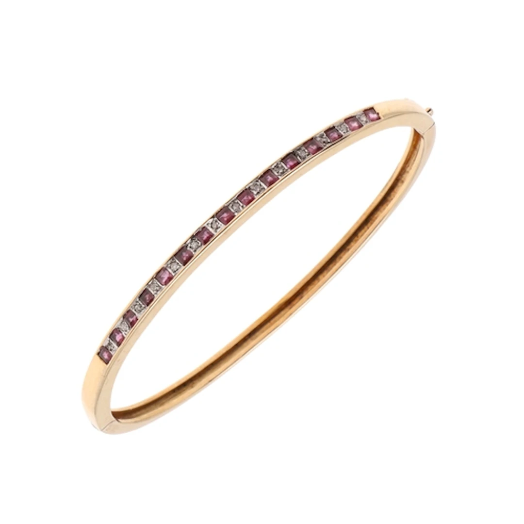 A RUBY AND DIAMOND HALF HINGED BANGLE. mounted to one side w...