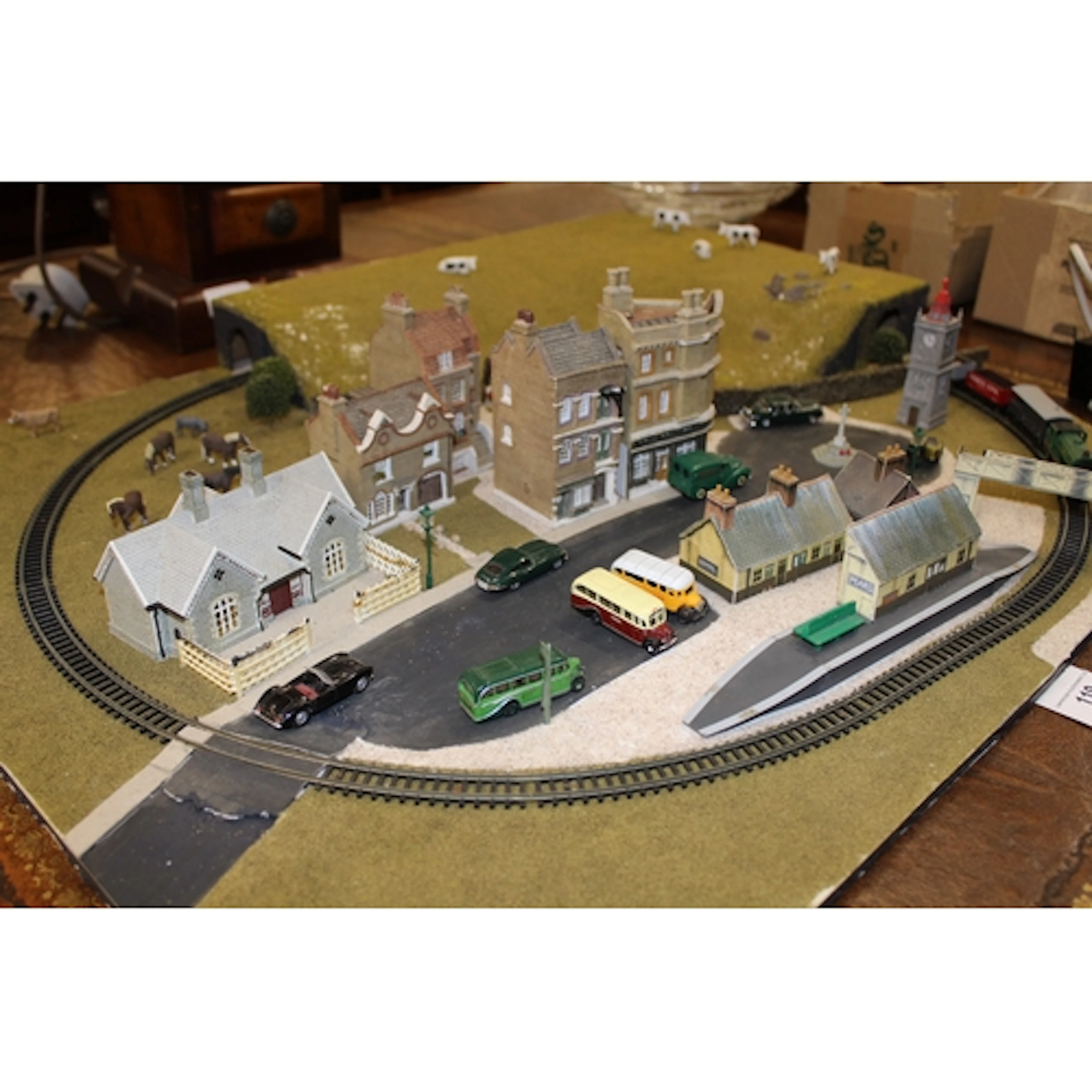 N gauge engine and rolling stock mounted on a board with vil...