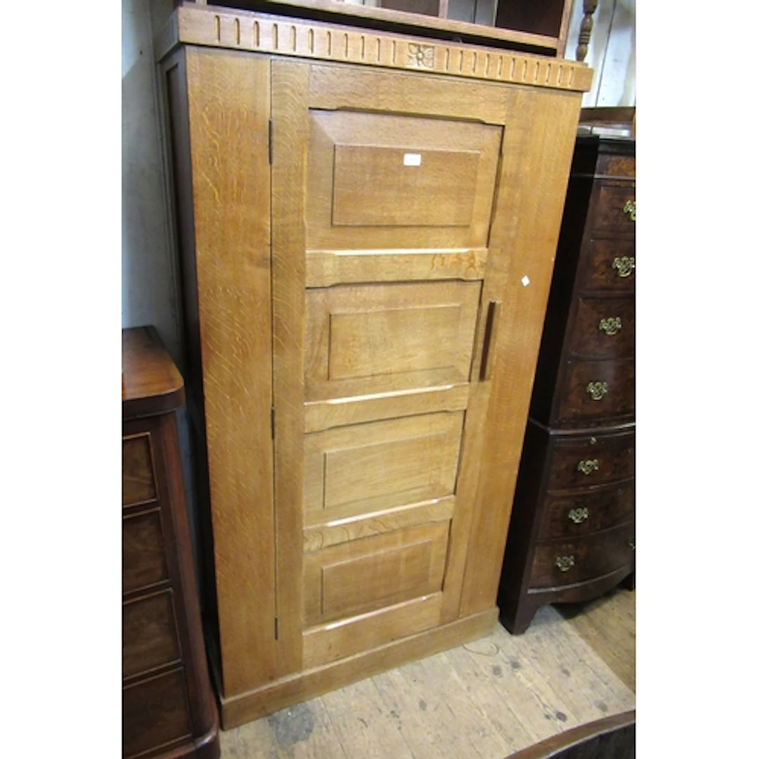 Arts & Crafts oak hall wardrobe, with a moulded frieze above...