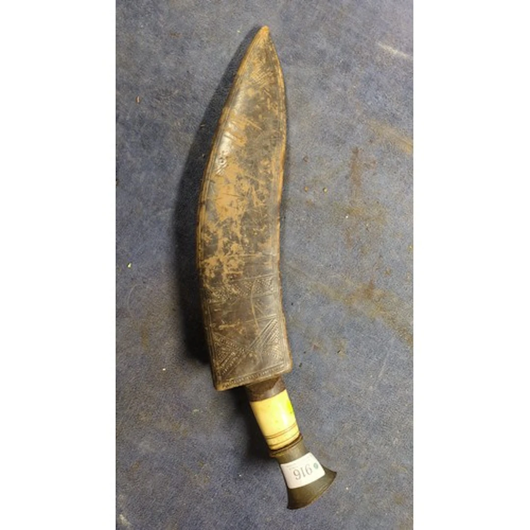 Kukri with a broad, inward-curving steel blade, pale grip an...