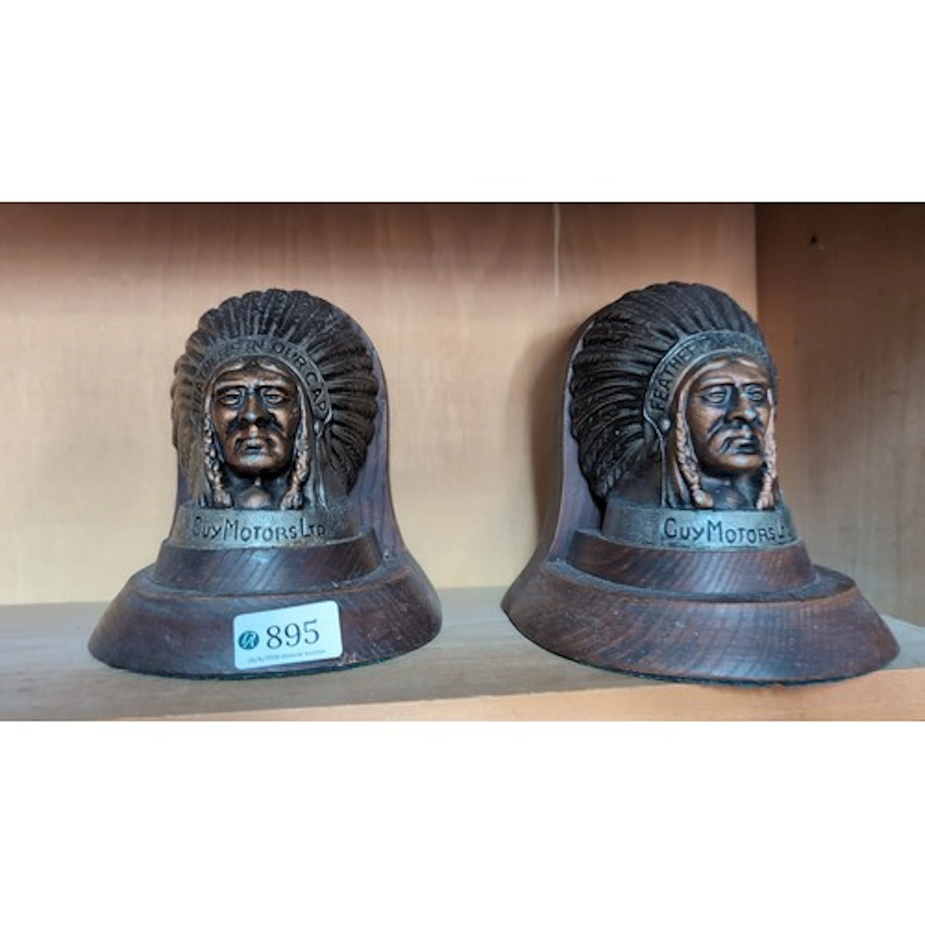 A pair of oak bookends inset with cast metal plaques modelle...