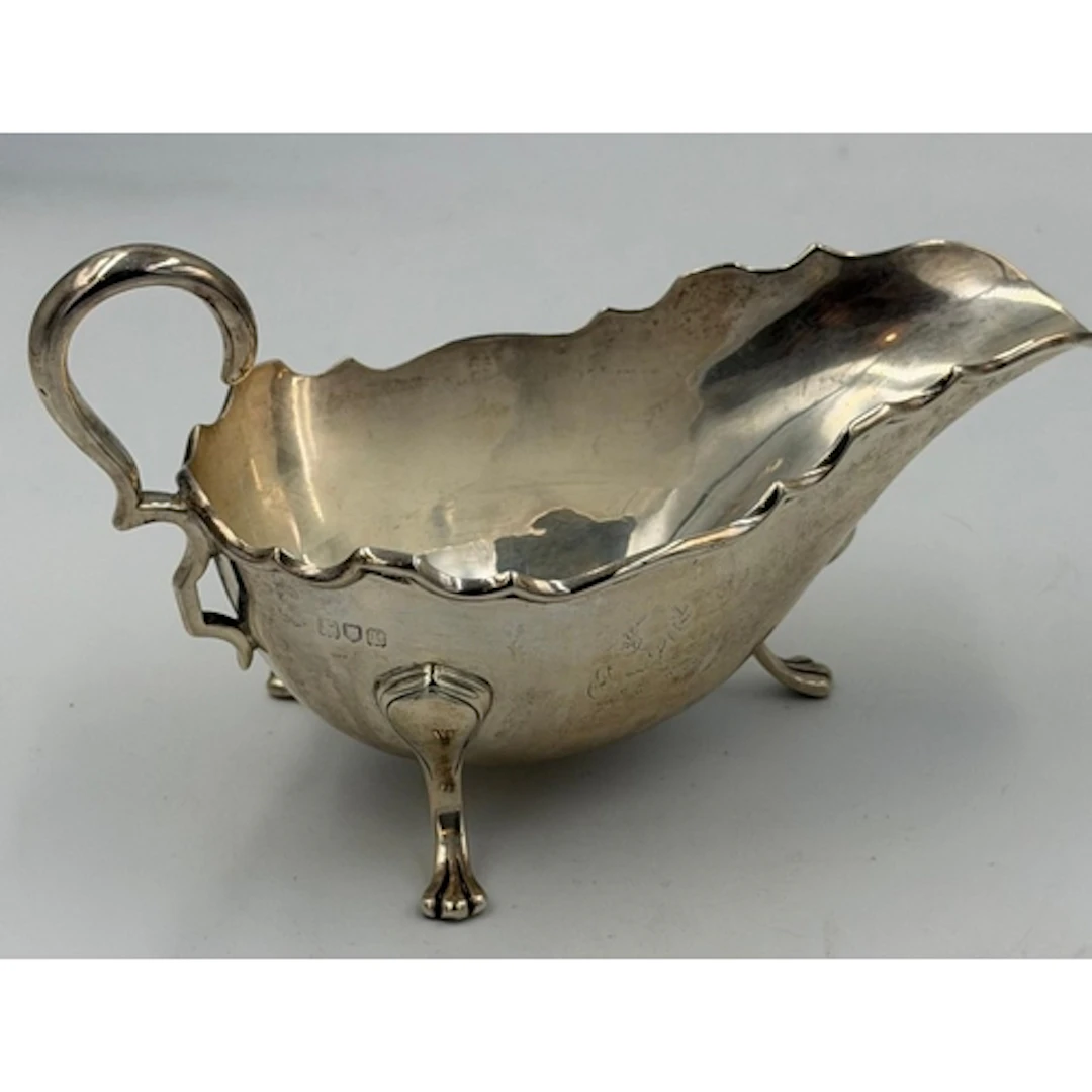 A hallmarked silver sauce boat on three paw feet, hallmarked...