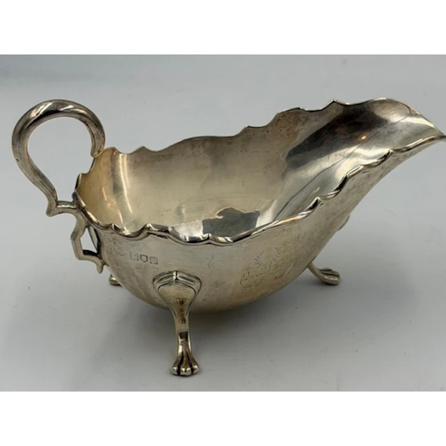 A hallmarked silver sauce boat on three paw feet, hallmarked...