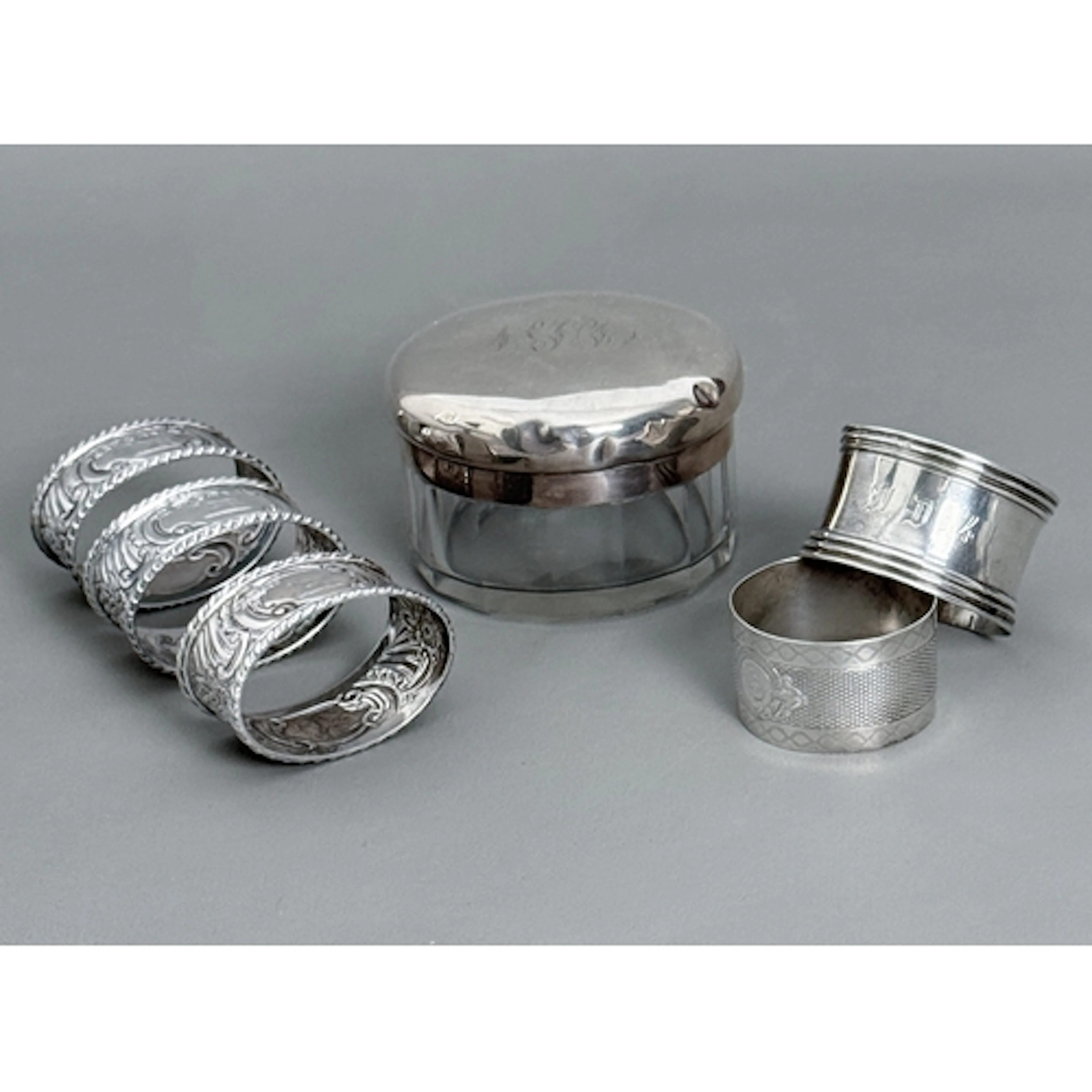 Five silver napkin rings - including a set of three Victoria...