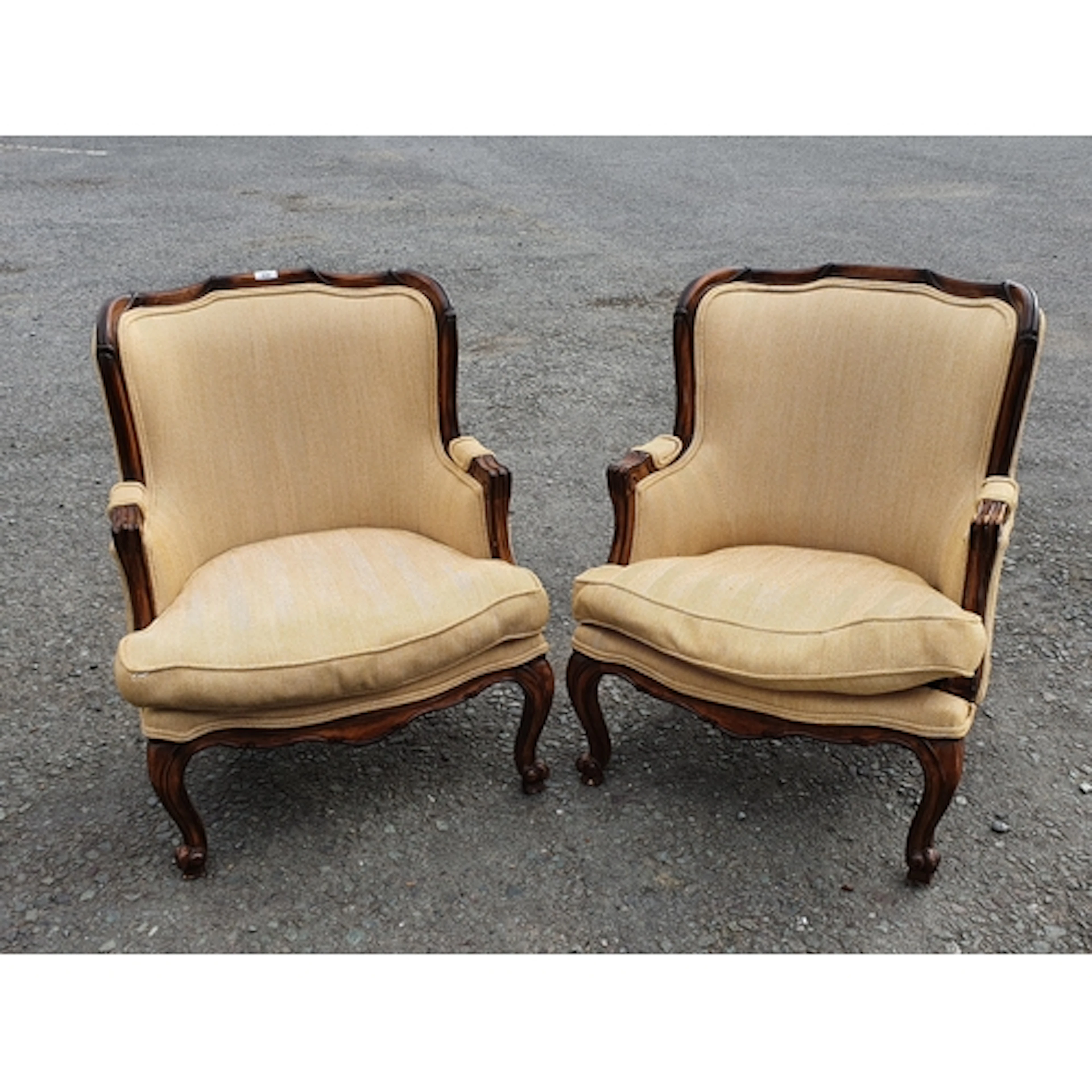 A pair of cream upholstered wingback Armchair raised on cabr...