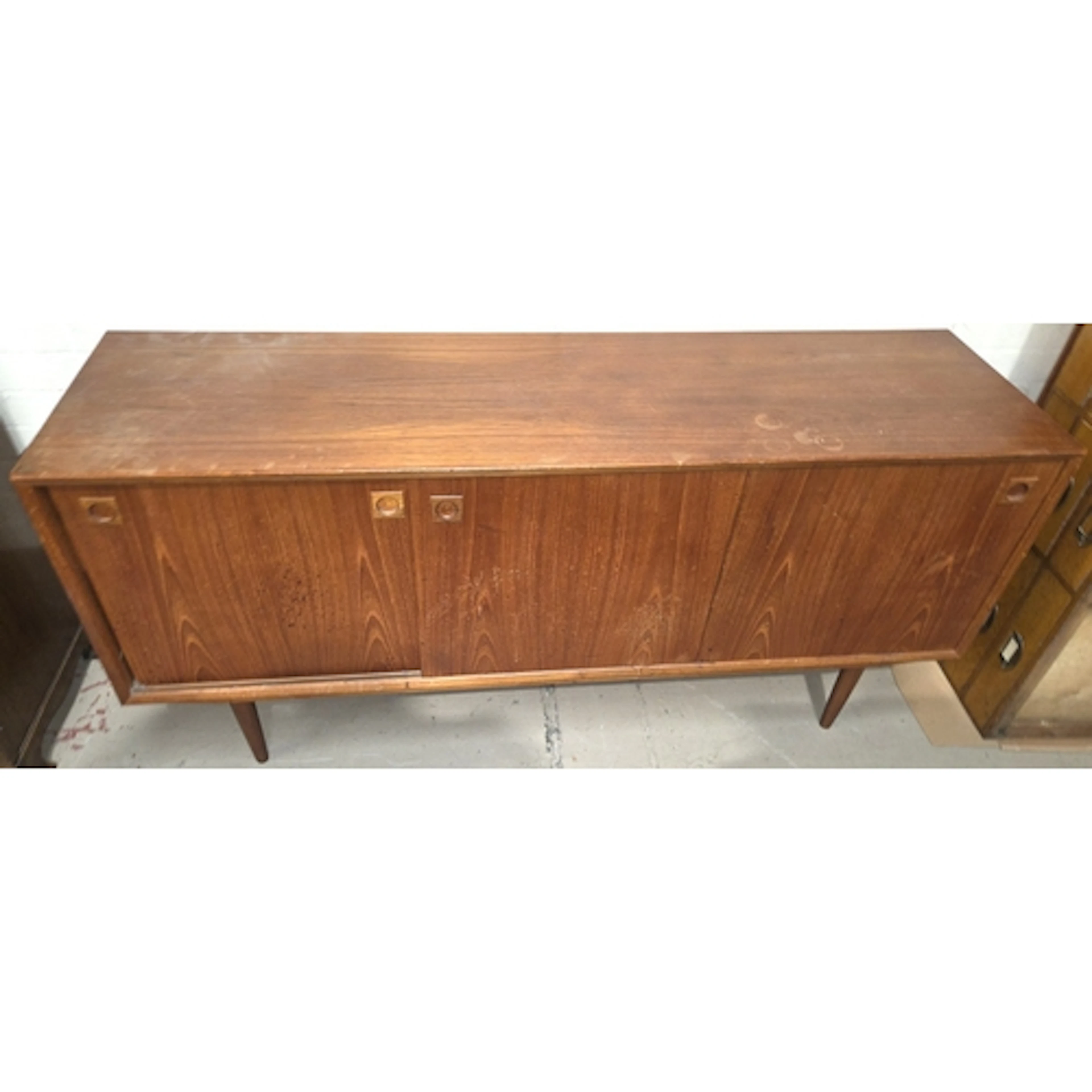 A mid 20th century teak sideboard with sliding doors and int...