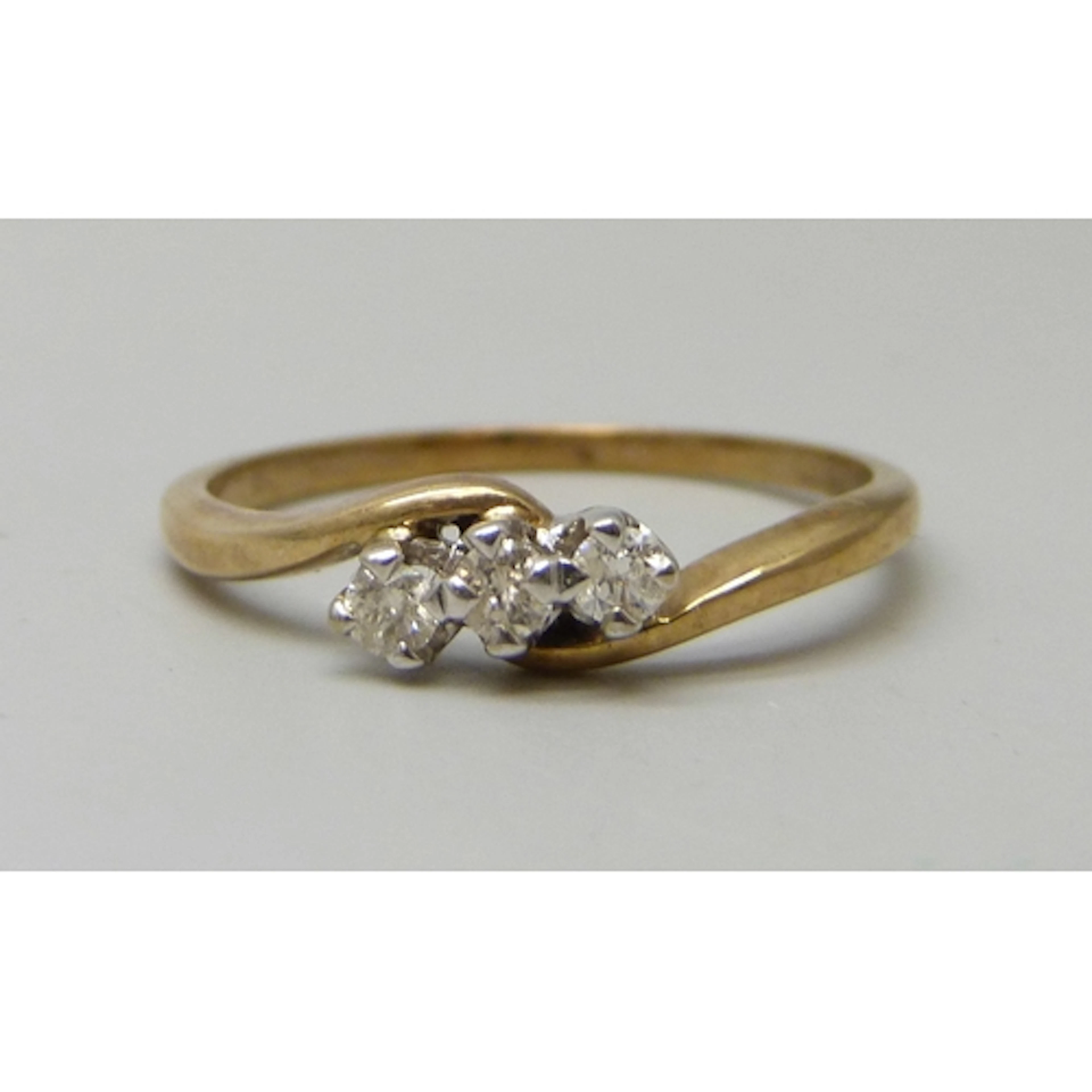 A yellow metal three stone diamond ring, marks illegible, 2....