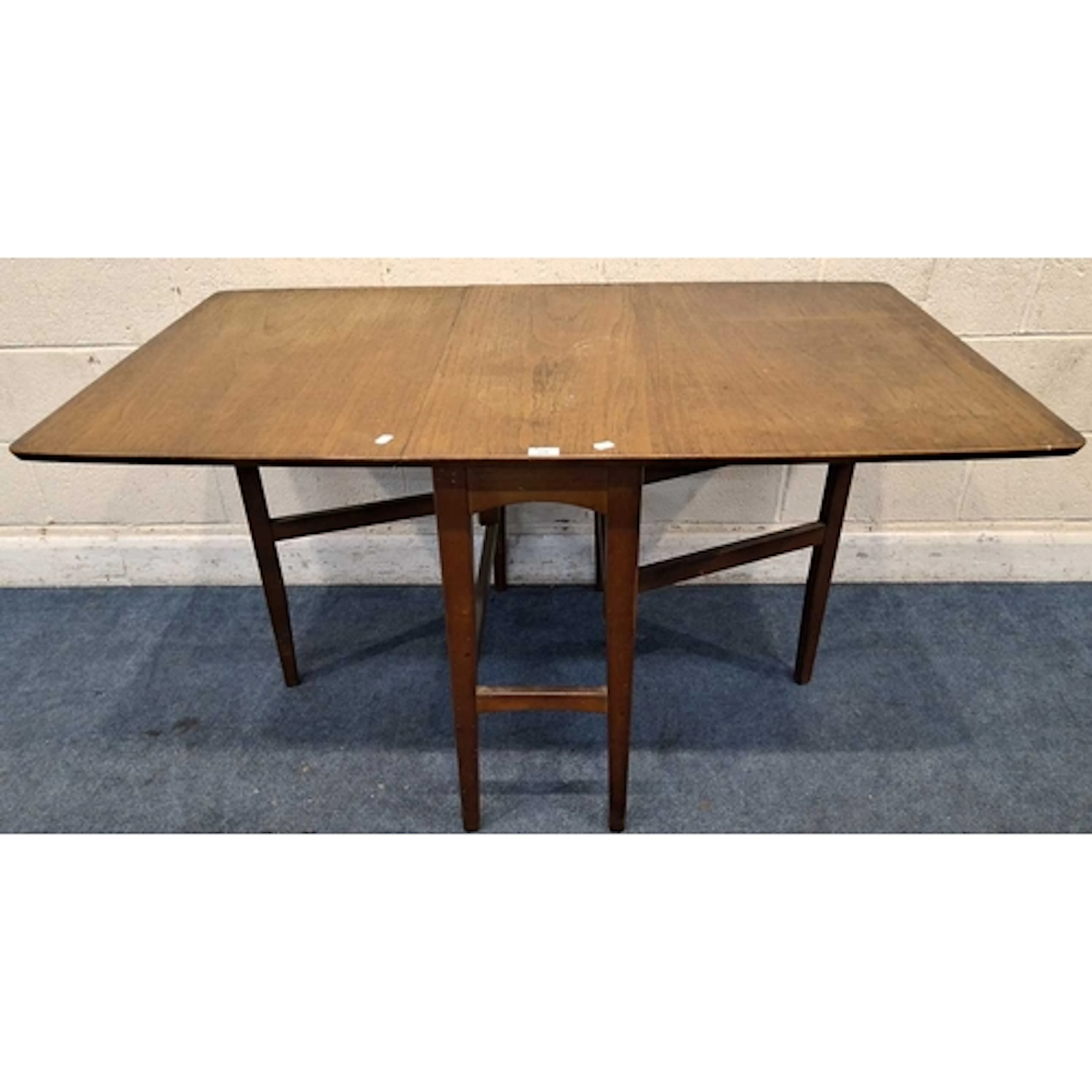A MID-CENTURY TEAK GATE LEG TABLE, raised on tapered legs, u...
