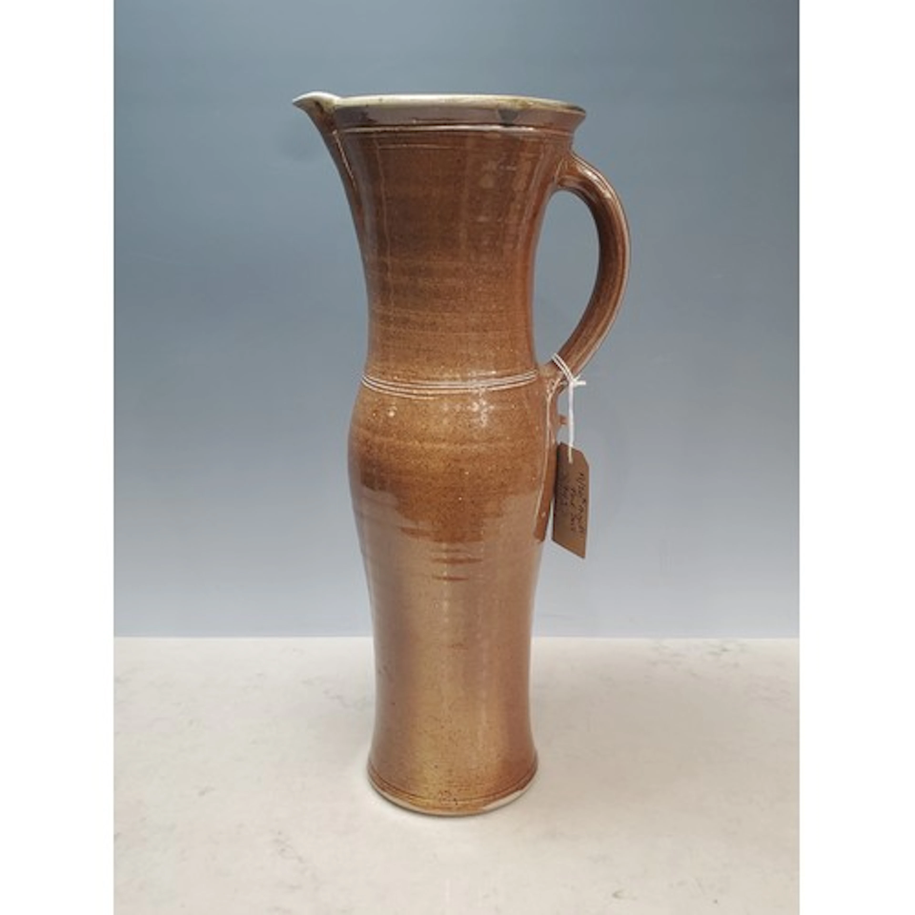 A tall slender salt-glazed stoneware Jug by Michael Casson (...
