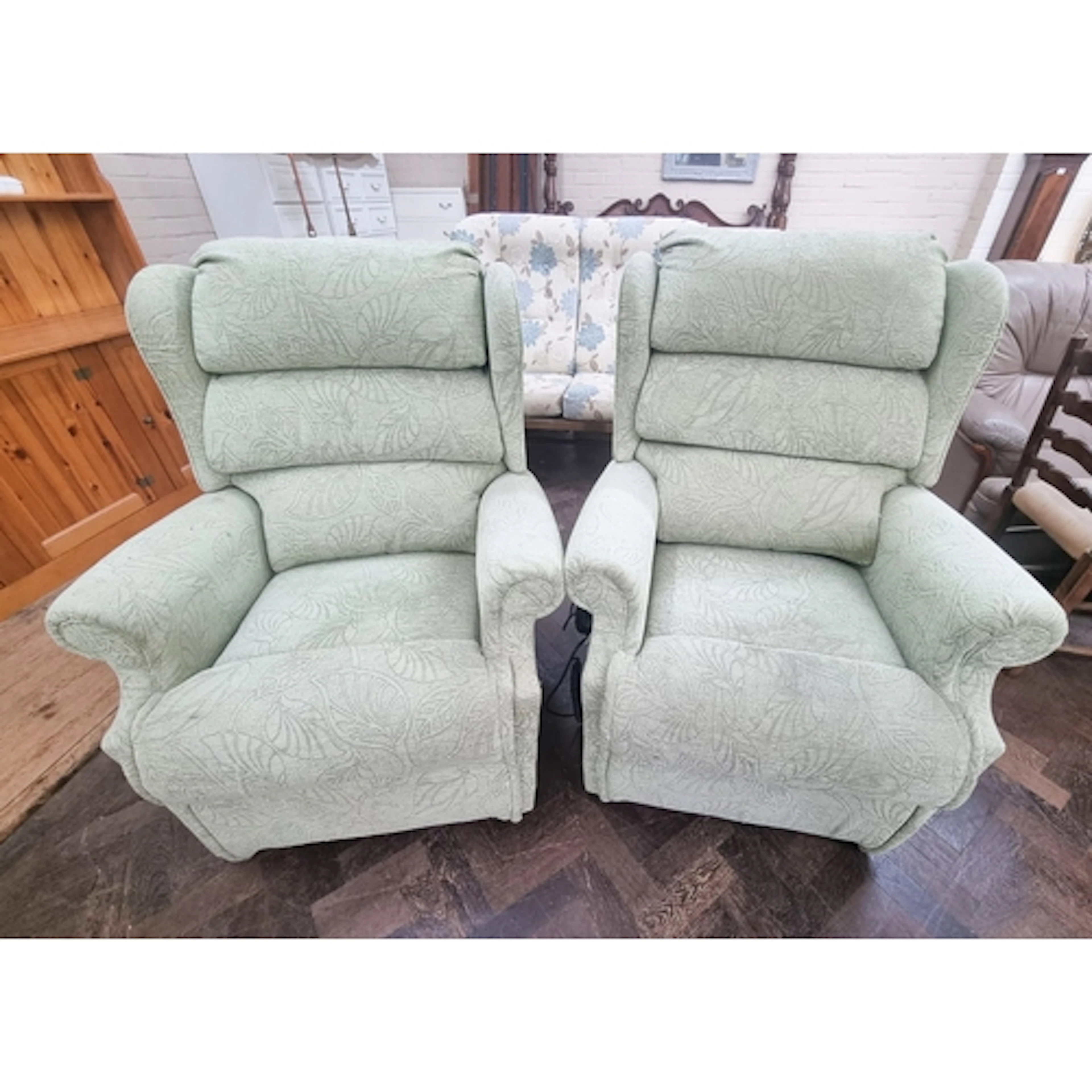 A pair of pale green upholstered electrically operated recli...