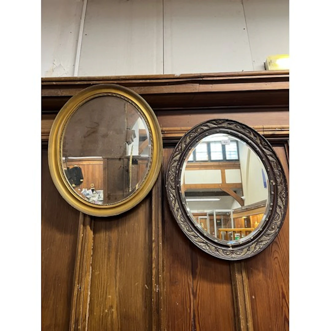 Two oval wall mirrors.