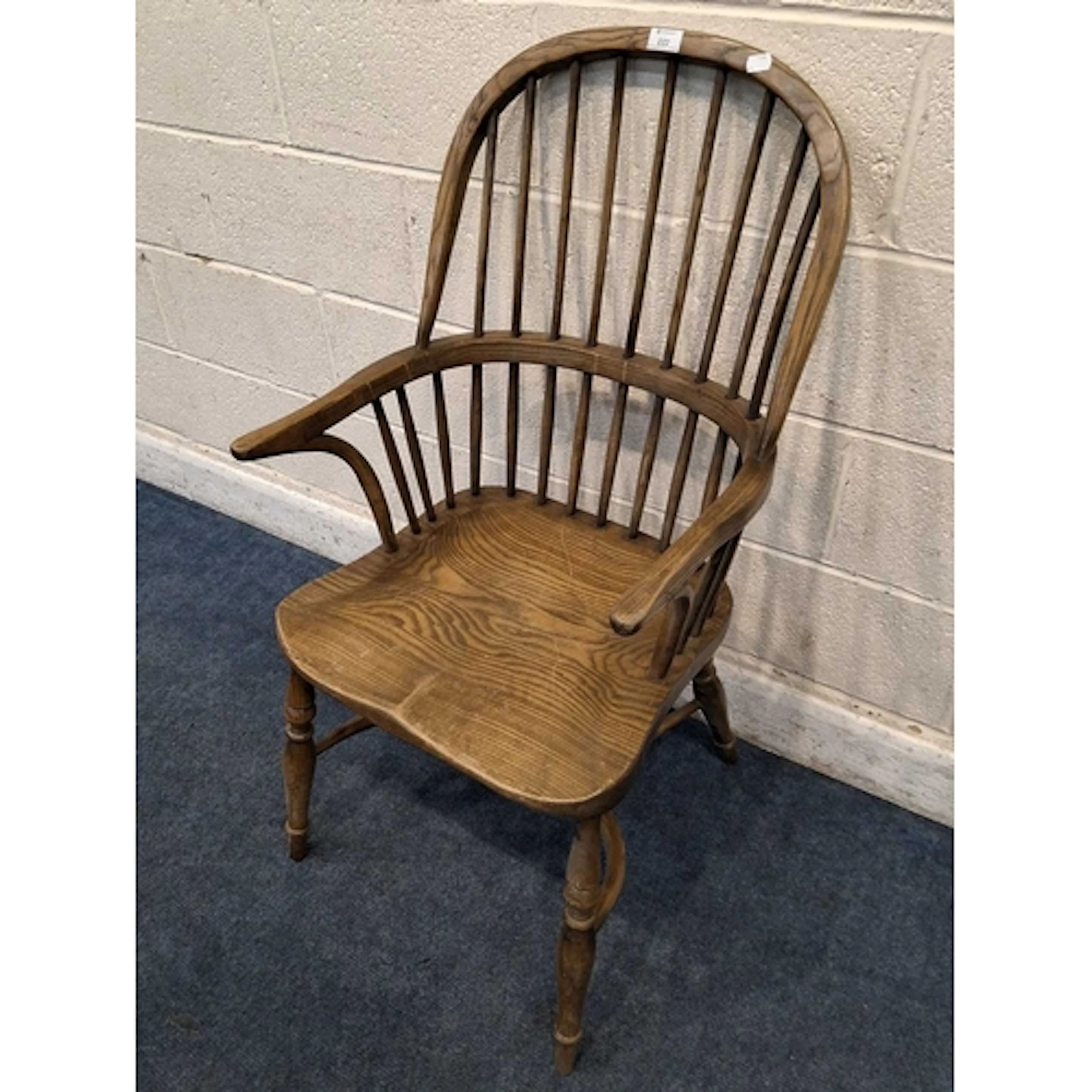 AN EARLY 20TH CENTURY ELM ARMCHAIR, with a spindle back, ben...
