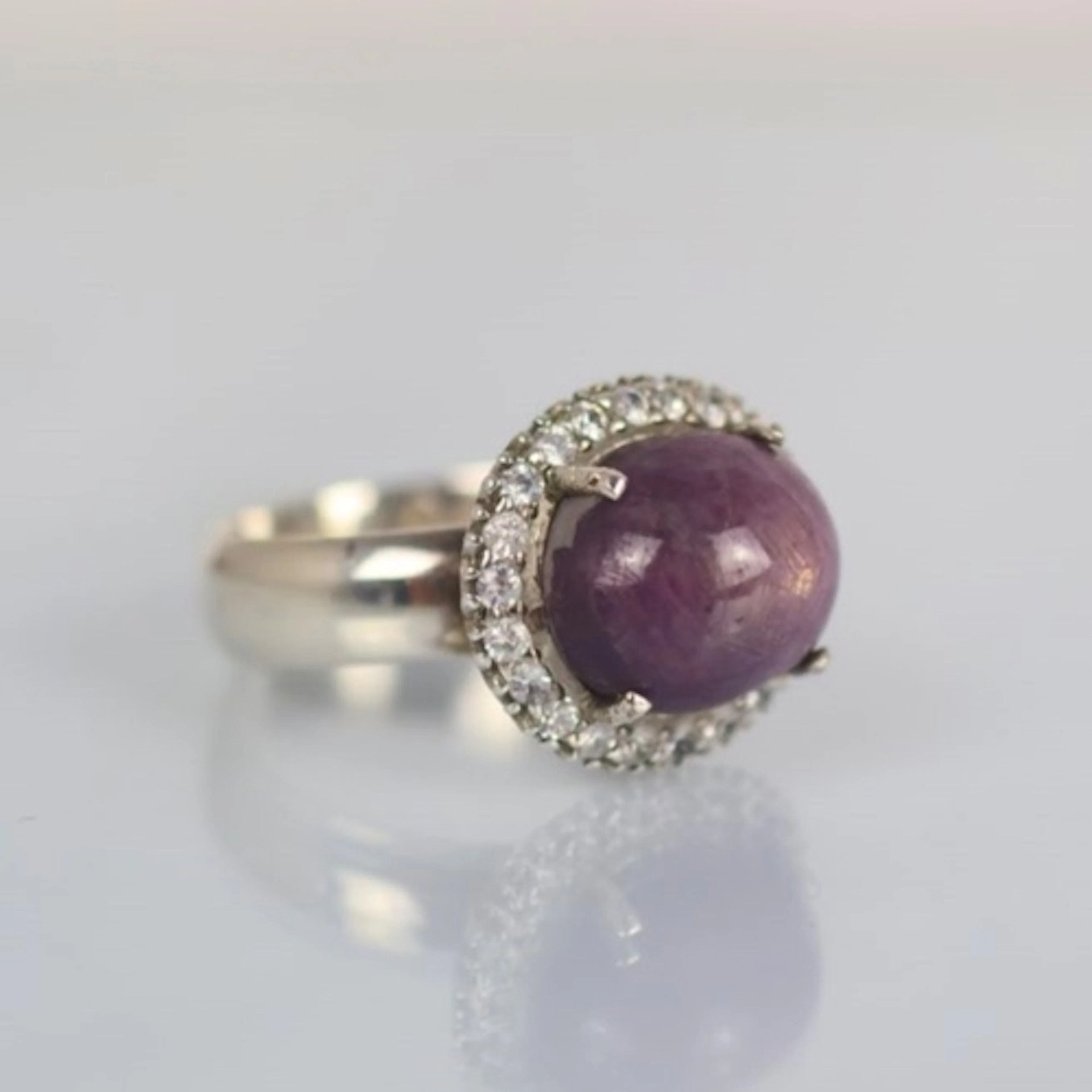 A contemporary ruby ring, the cabochon stone within cluster ...