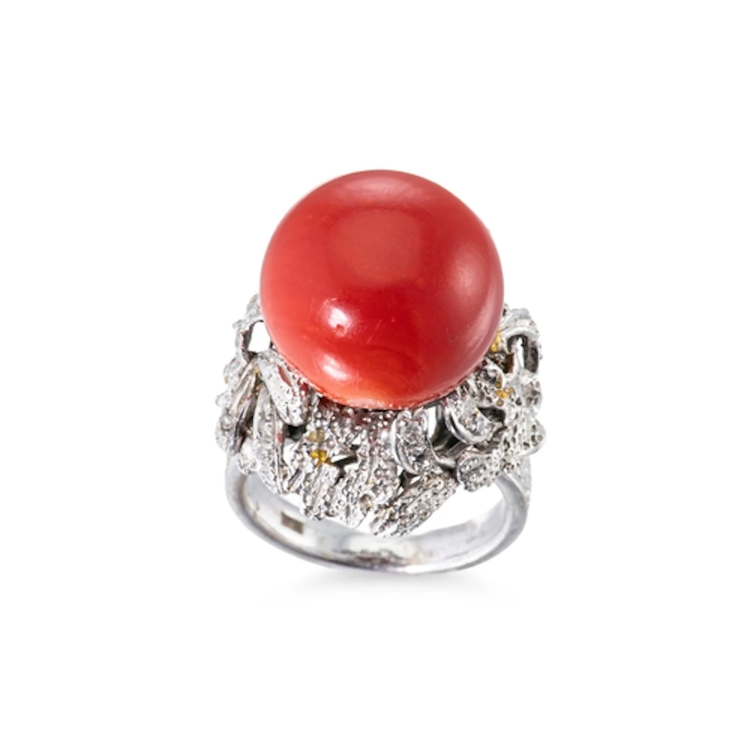 A CORAL AND DIAMOND CLUSTER RING, the large round cabochon c...