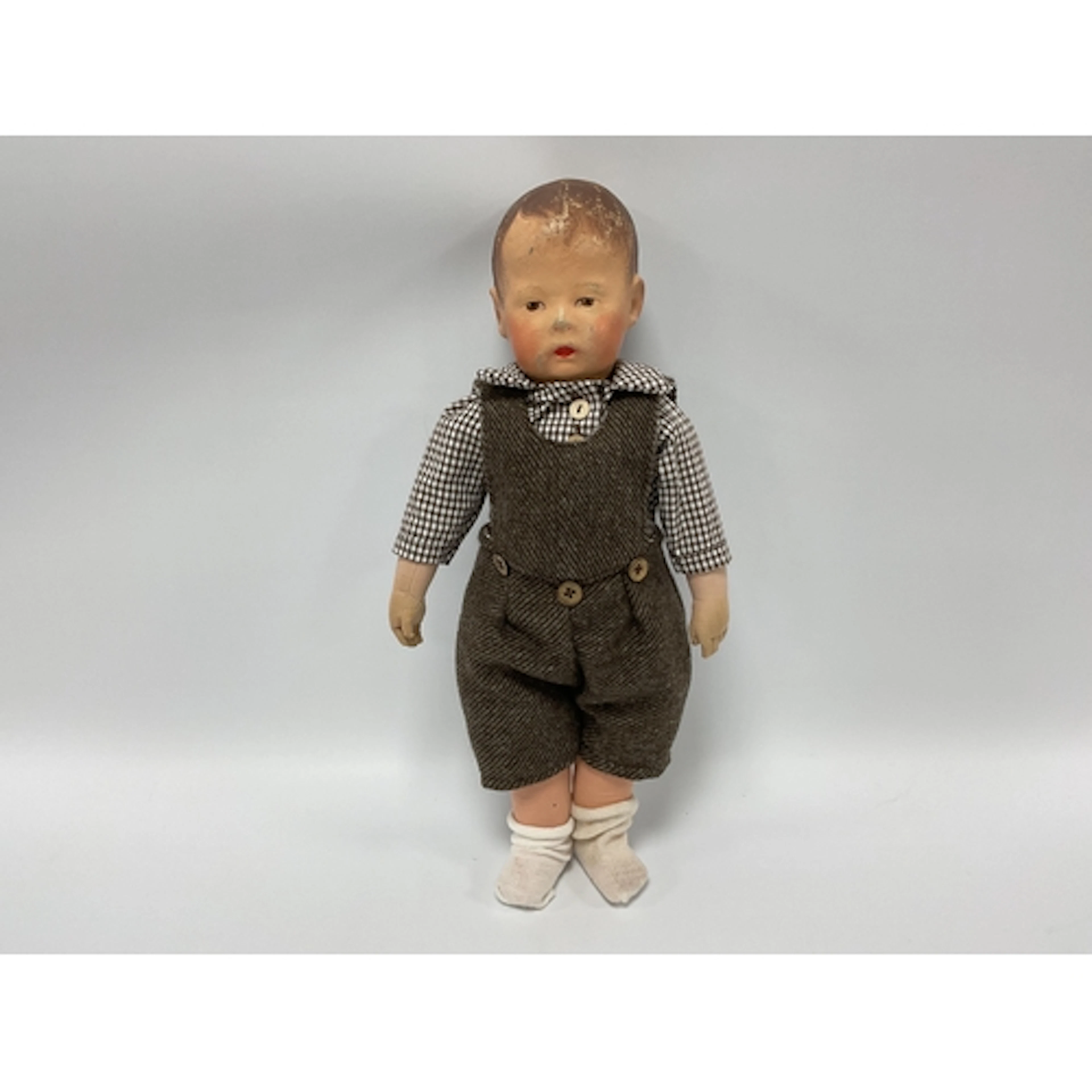 A Kathe Kruse Doll, with painted head, painted hair and clot...