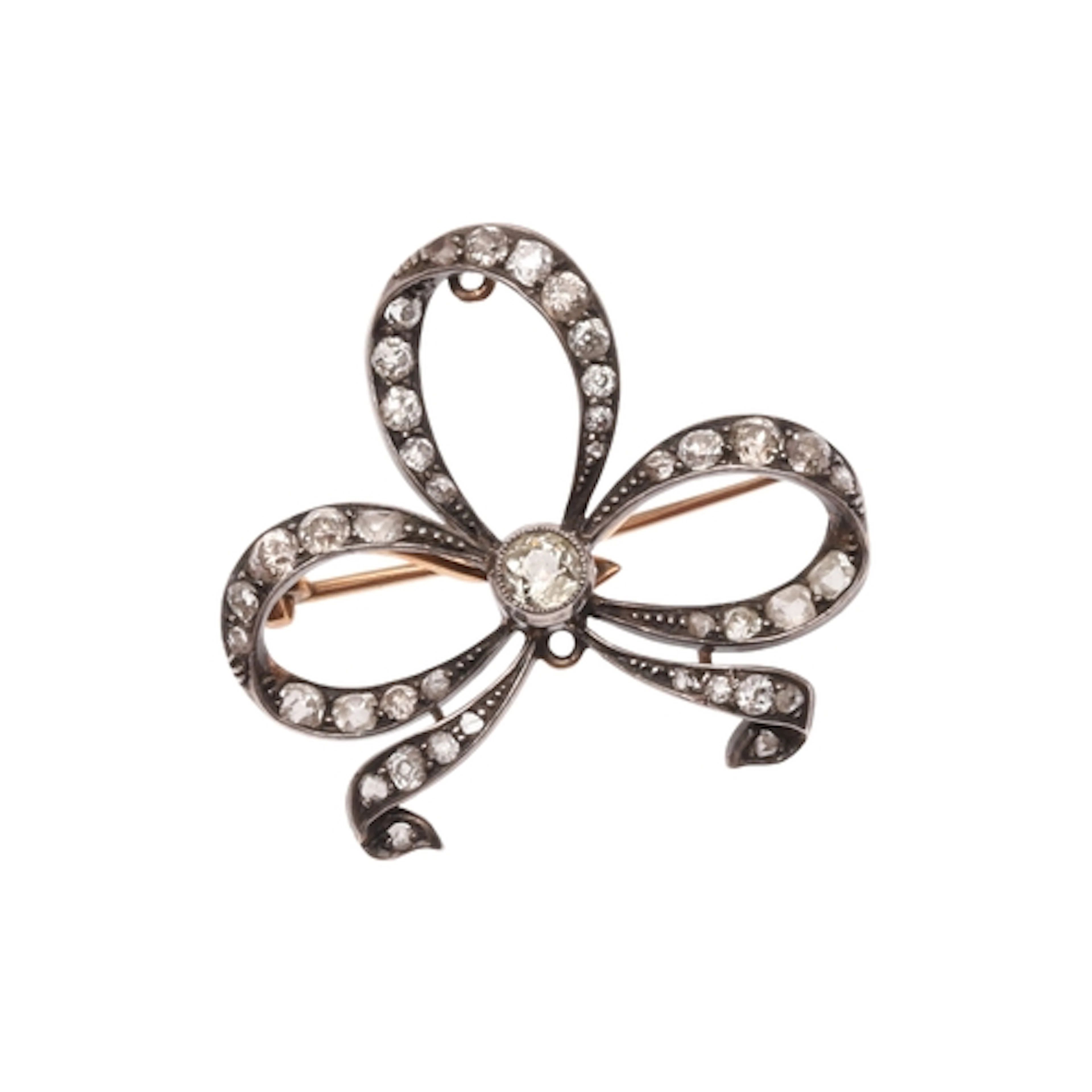 A VICTORIAN DIAMOND BROOCH PENDANT. formed as a tied bow, se...