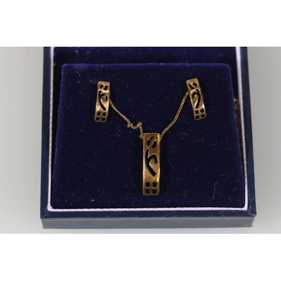 Gold tone pendant and pair of matching earrings and a gold n...