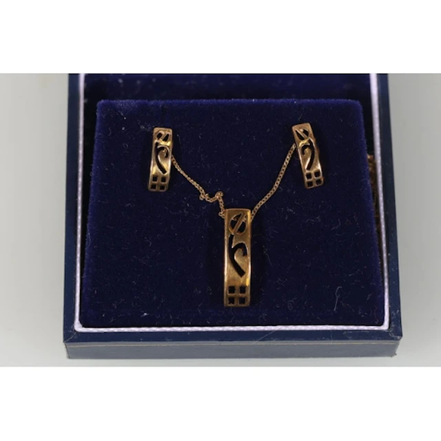 Gold tone pendant and pair of matching earrings and a gold n...