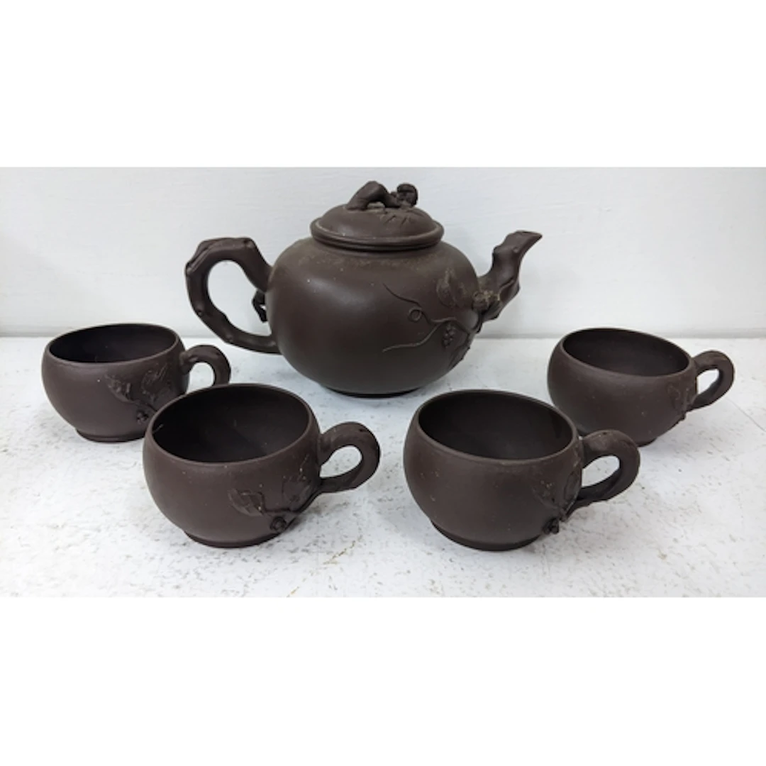 A Chinese terracotta Yixing teapot together with four matchi...