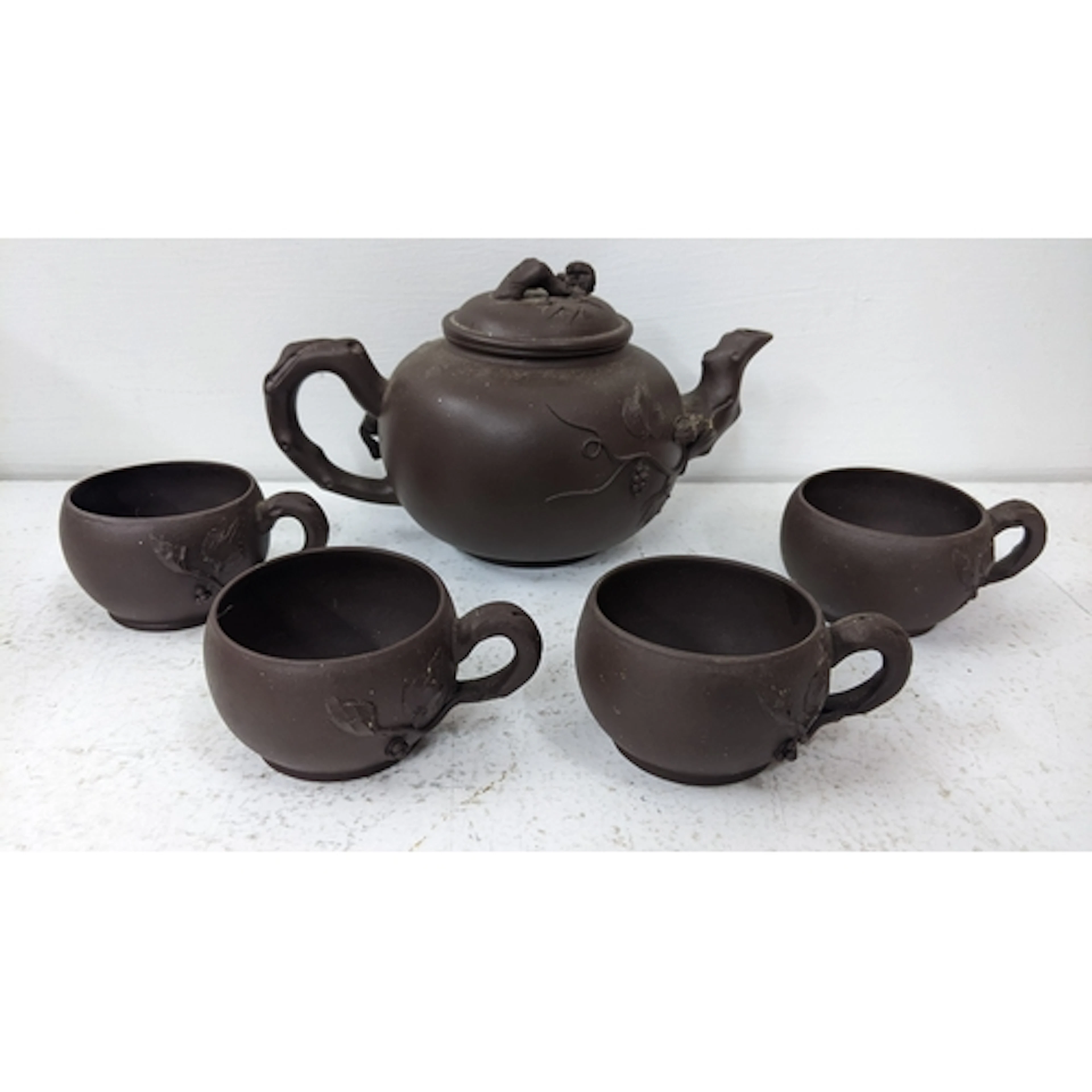 A Chinese terracotta Yixing teapot together with four matchi...