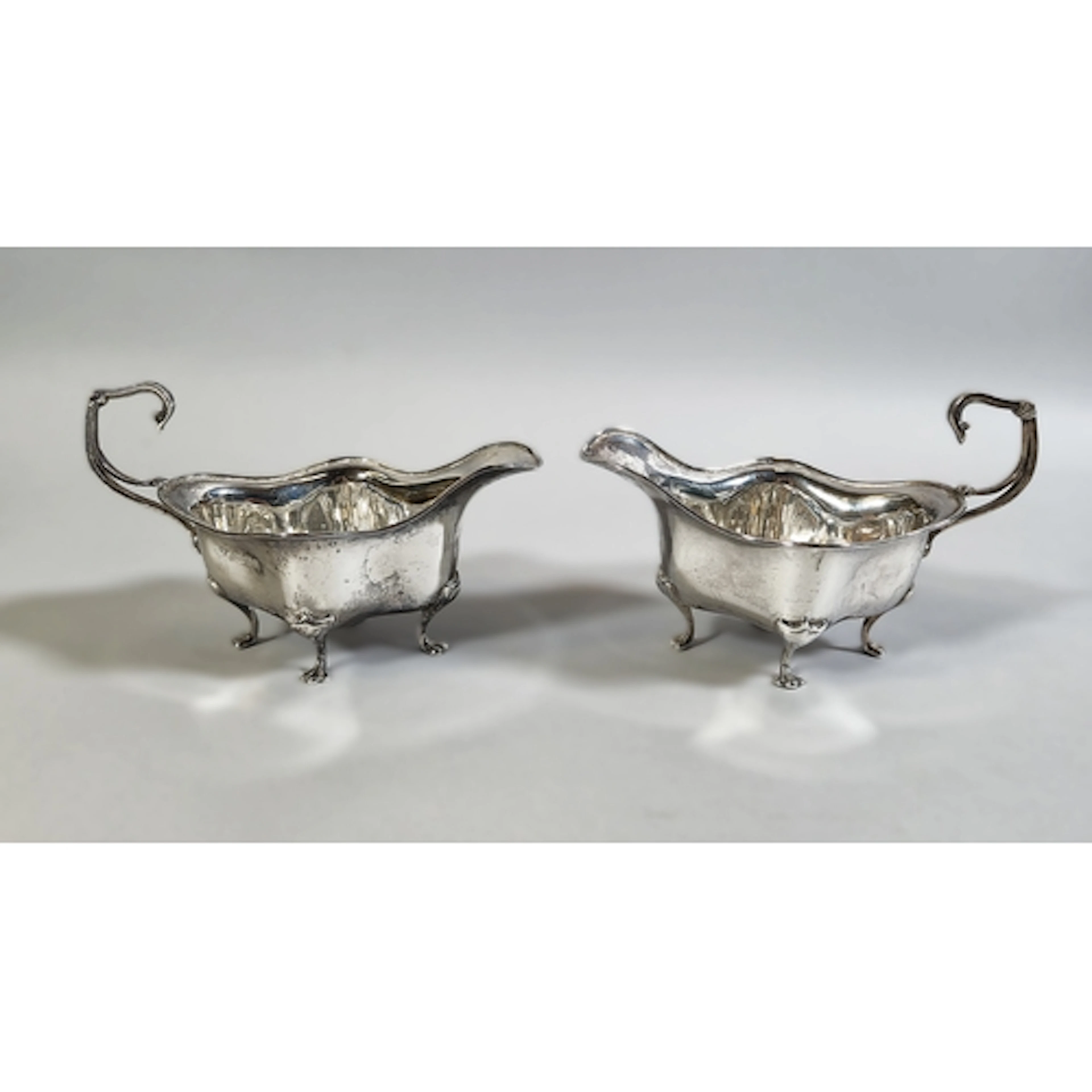 Pair of Edward VII silver sauce boats of wavy boat shape wit...