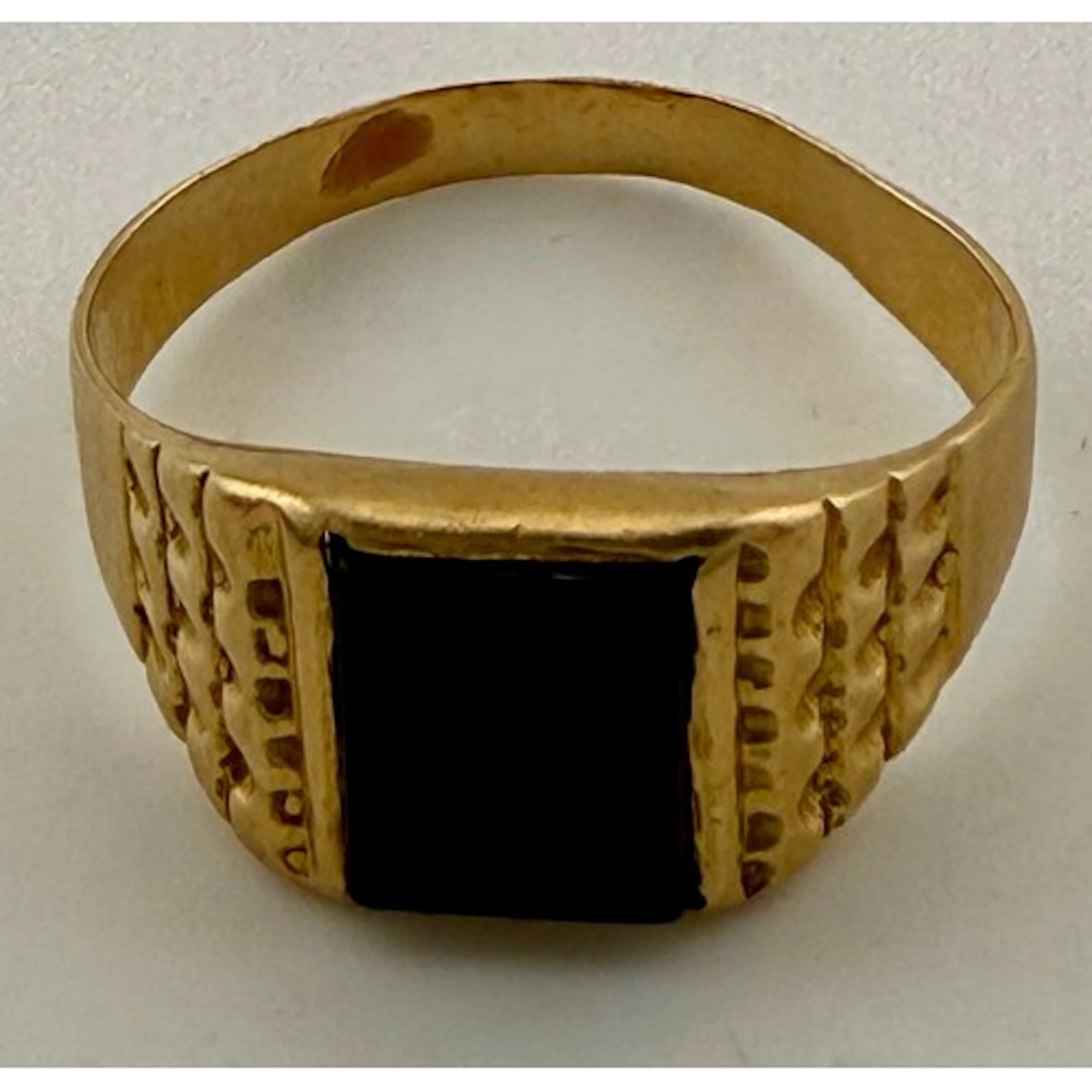An 18 carat gold ring set with black onyx. Weight 5gm.
